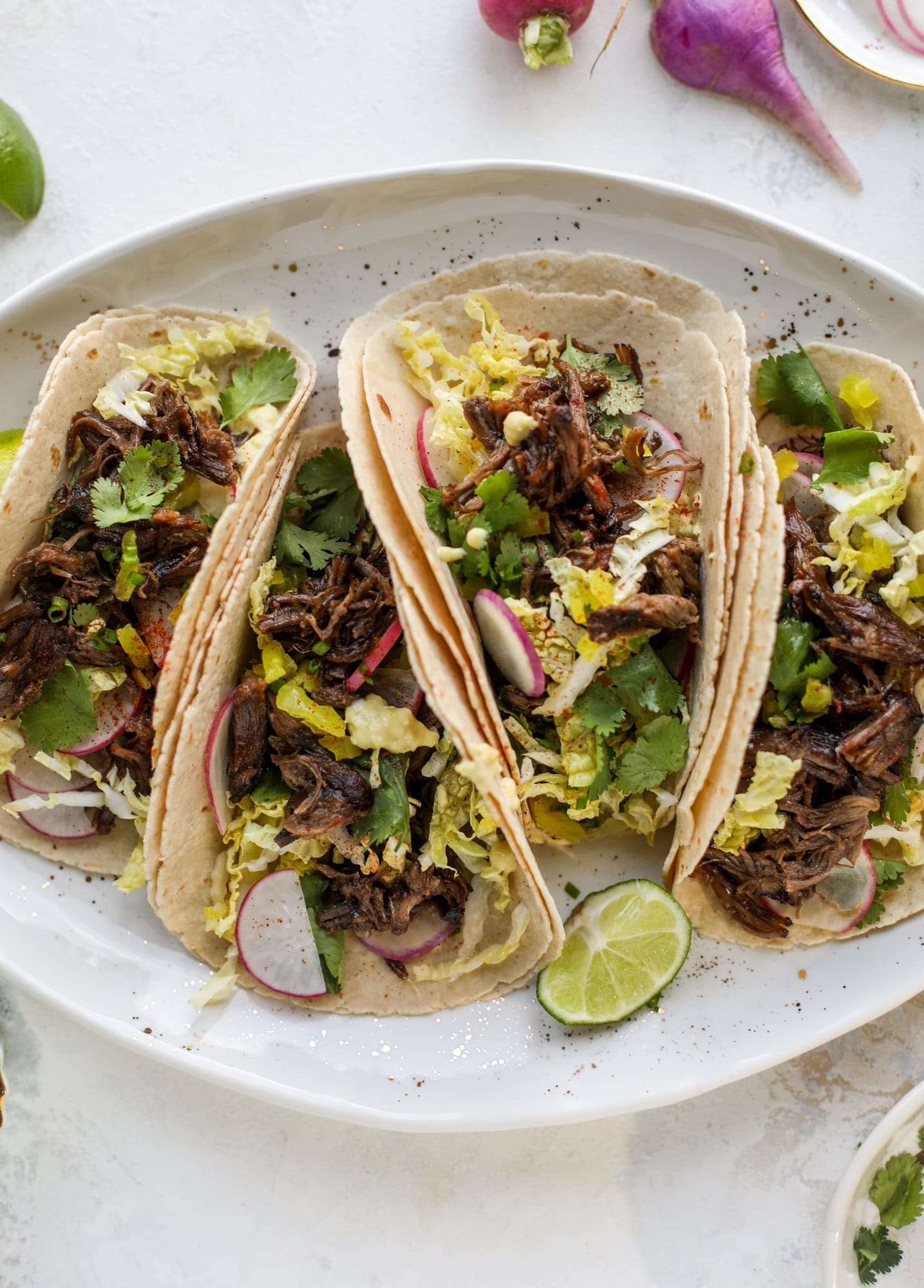 These are the best smoky short rib tacos made in the slow cooker! Served with a banana pepper mustard and napa cabbage slaw, it's a flavor explosion.
