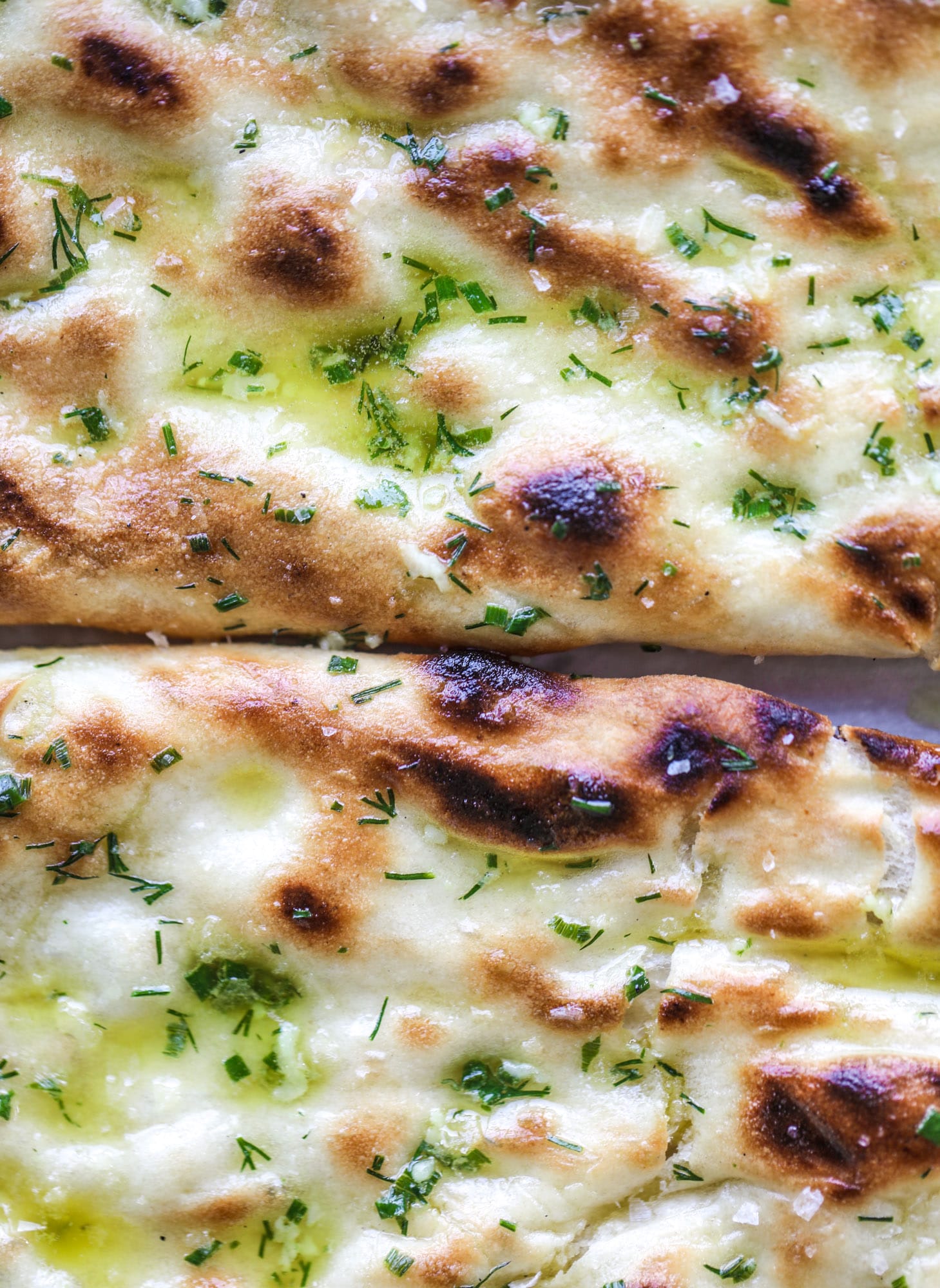 Grilled focaccia bread is such a treat! Topped with puddles of garlic butter, fresh chopped herbs and golden, caramelized onions, it's a slice of heaven.