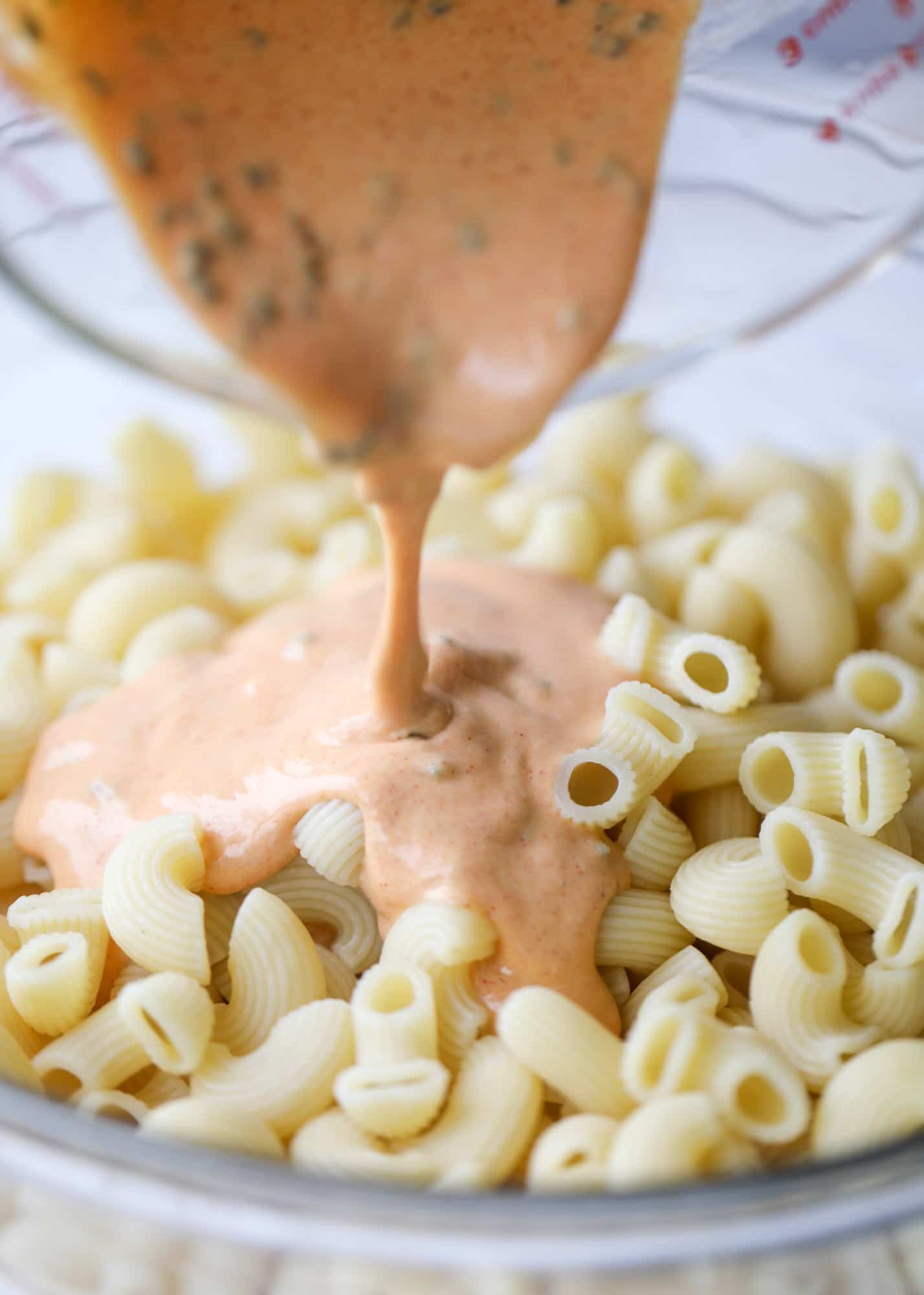 pouring dressing on pasta salad