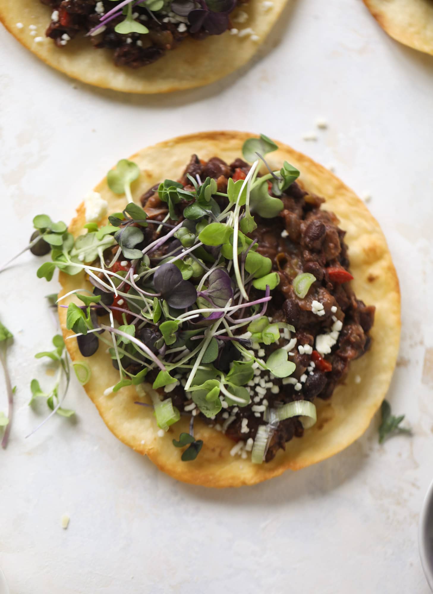 These saucy black bean tostadas are super flavorful and easy for a weeknight meal. Crunchy tortillas topped with beans and tons of veggies. Delish!