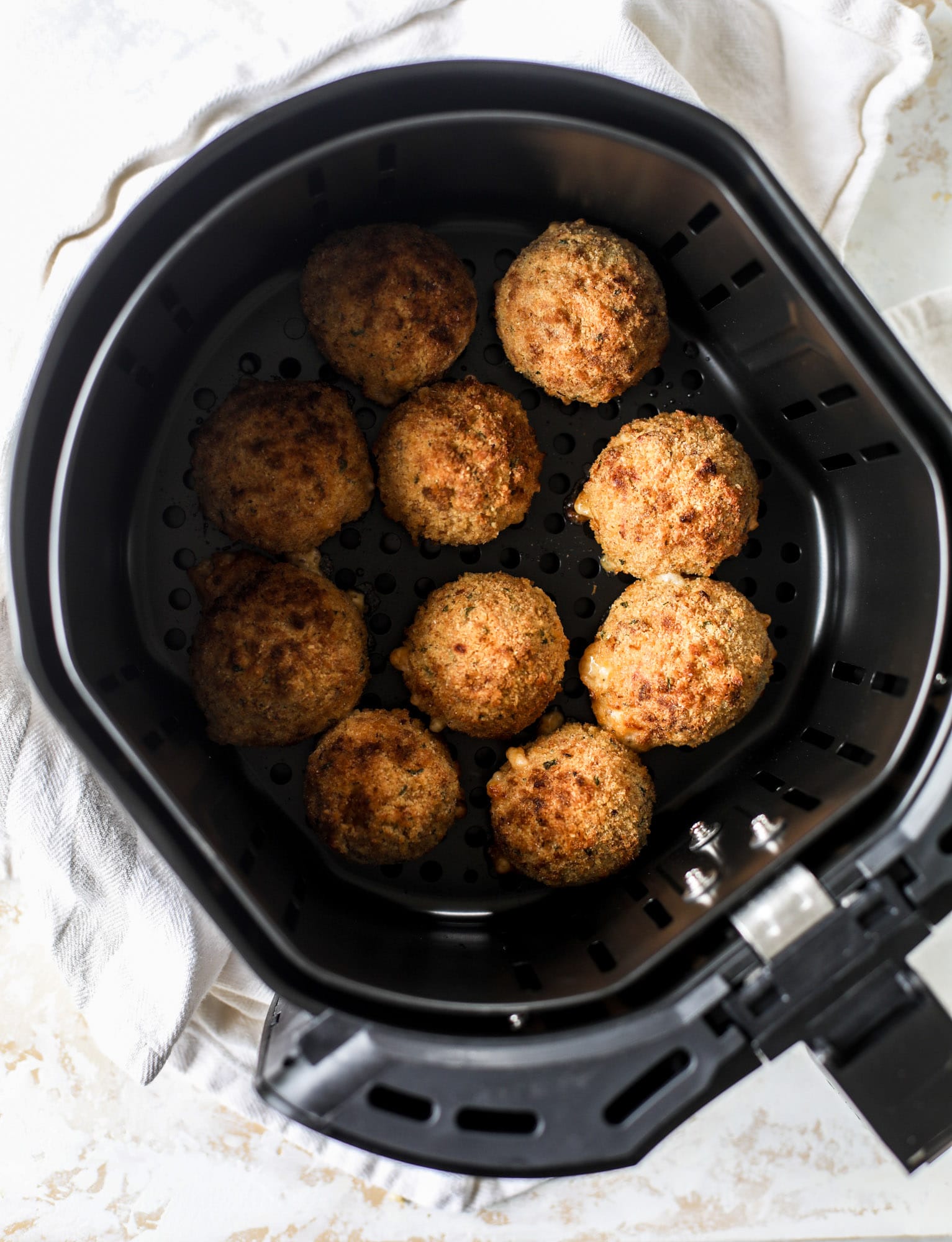 This cheesy cauliflower rice arancini is every bit as delicious as traditional arancini, and so much lighter! Cheesy on the side, crunchy on the outside.