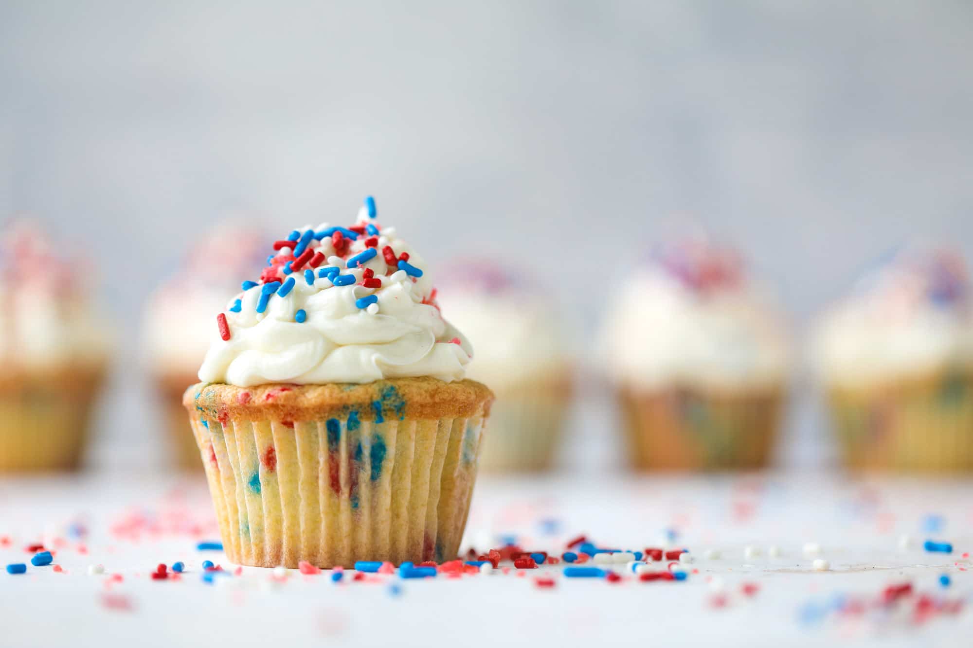 These 4th of July confetti cupcakes are super fun! Firecracker cupcakes with red, white and blue sprinkles and pop rocks candy on top for crackle! 
