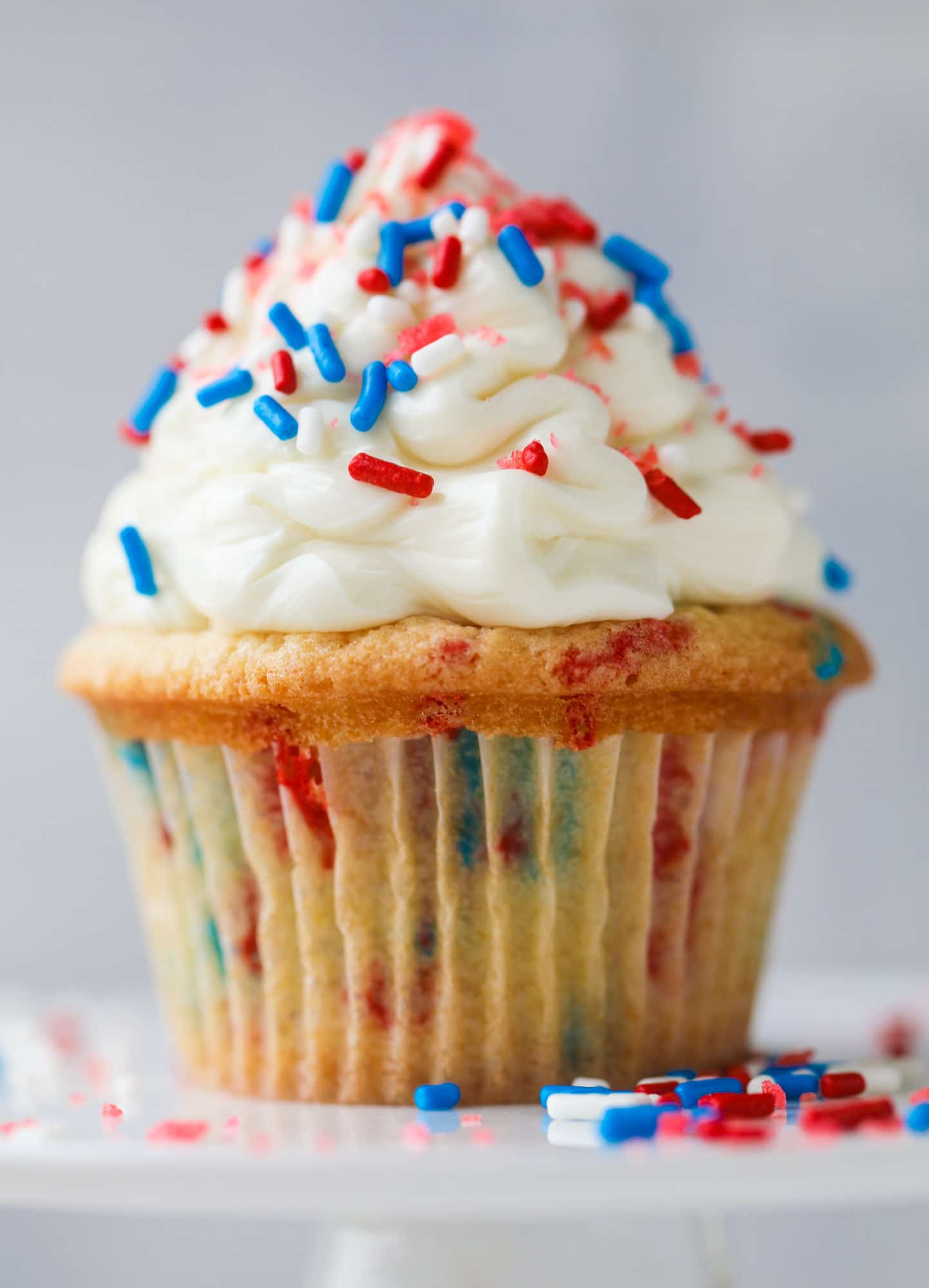 These 4th of July confetti cupcakes are super fun! Firecracker cupcakes with red, white and blue sprinkles and pop rocks candy on top for crackle! 