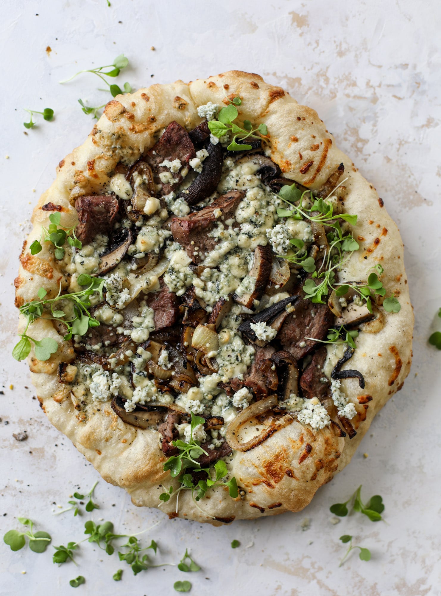 This grilled steakhouse pizza has all the amazing smoky flavors of your favorite steakhouse. Grilled onions, mushrooms and creamy gorgonzola finish it off.