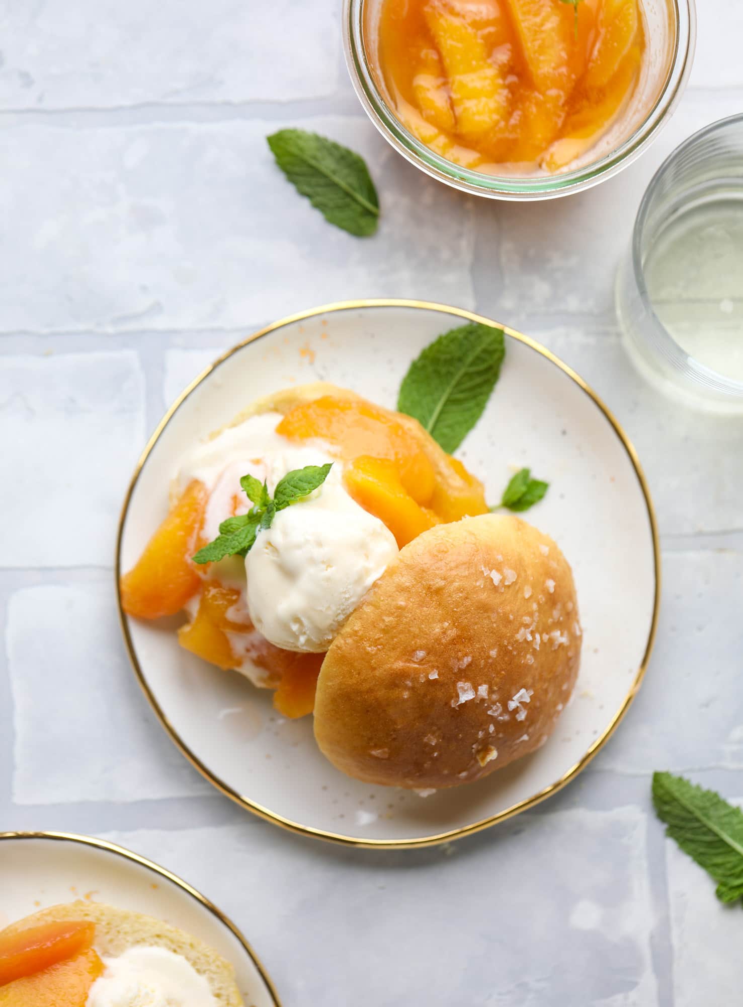 Prosecco peach shortcakes are out of these world! Prosecco poached peaches with vanilla ice cream on homemade salted brioche buns. To die for.