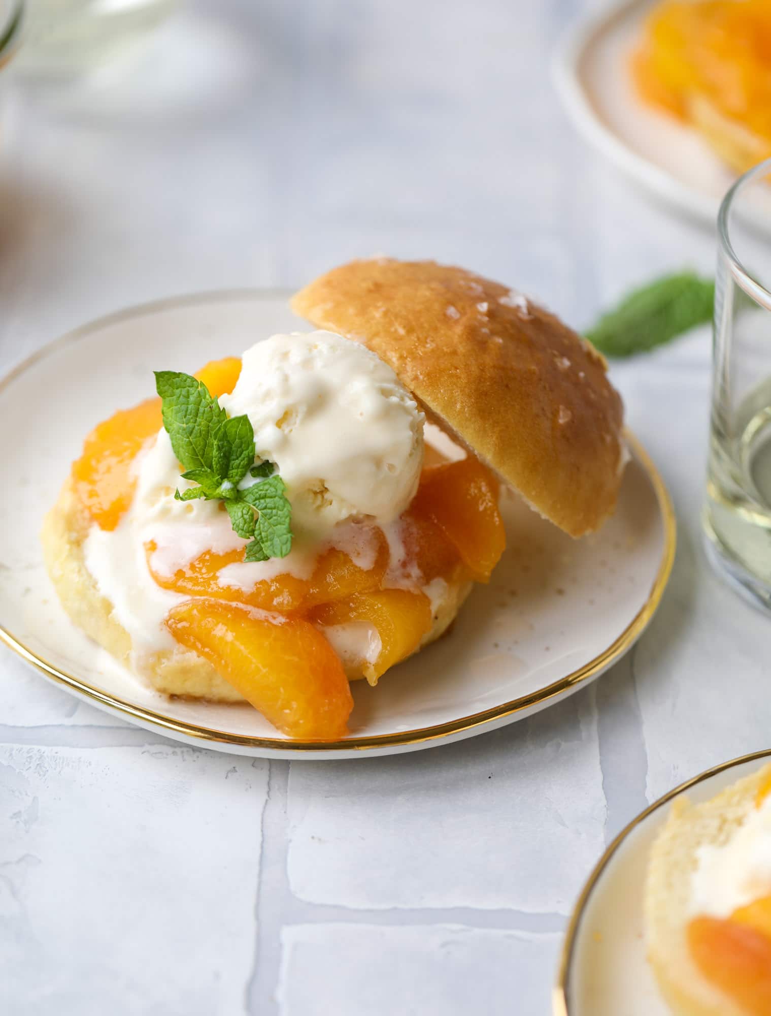 Prosecco peach shortcakes are out of these world! Prosecco poached peaches with vanilla ice cream on homemade salted brioche buns. To die for.