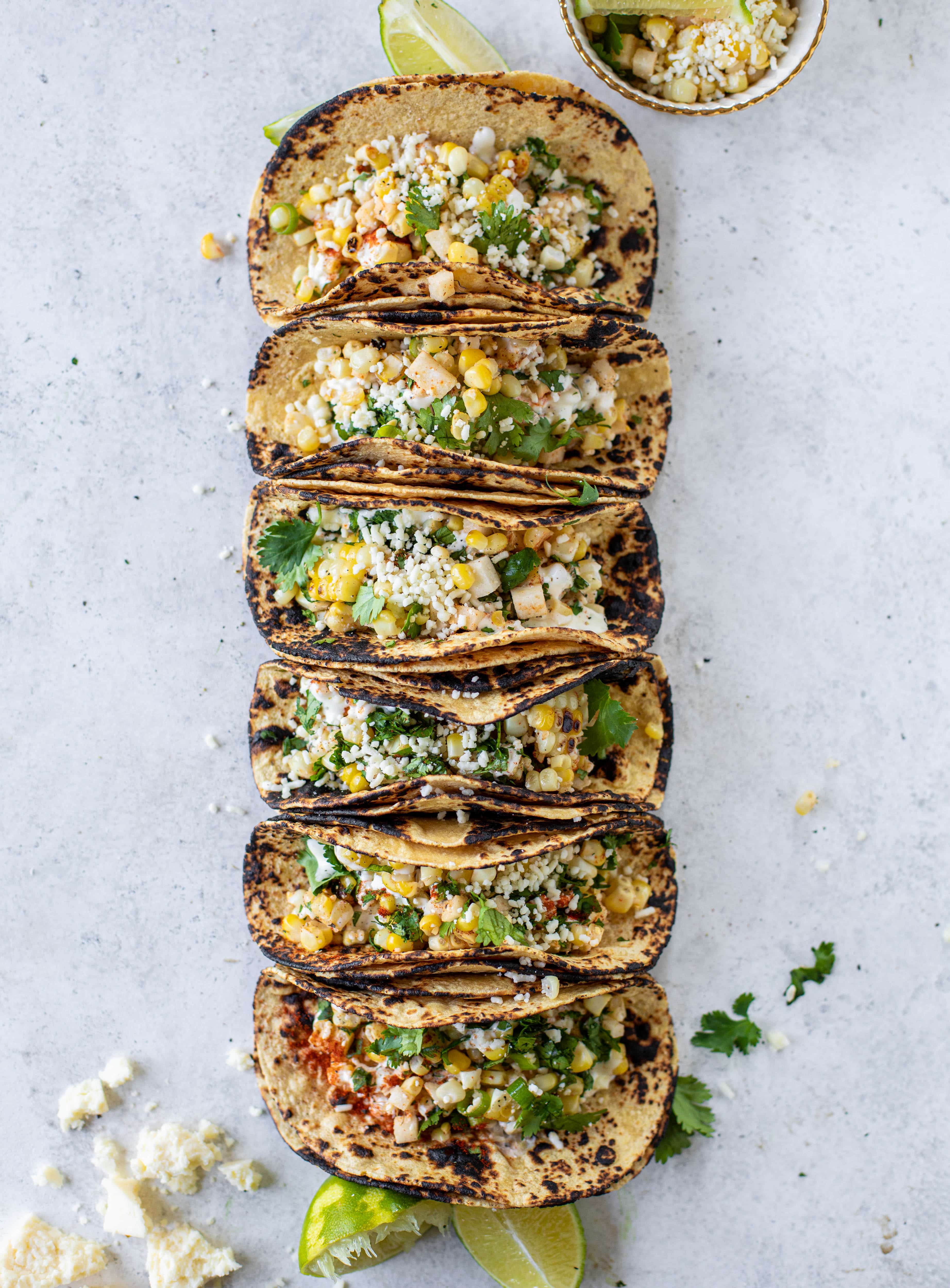 These street corn tacos are filled with a jicama corn salad and drizzled with garlic mayo. This little taco packs a major flavor punch.