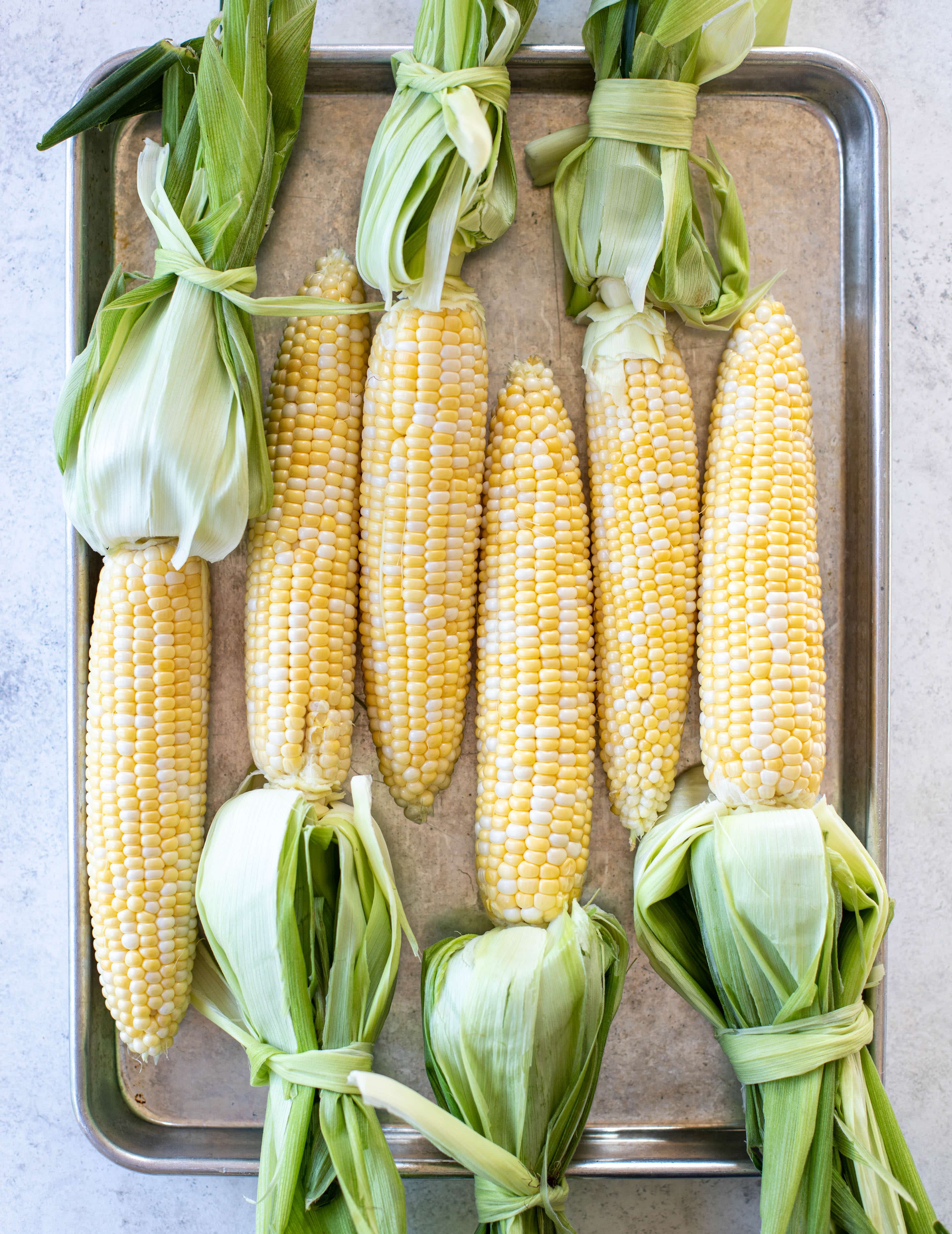 sweet corn with husks tied on 