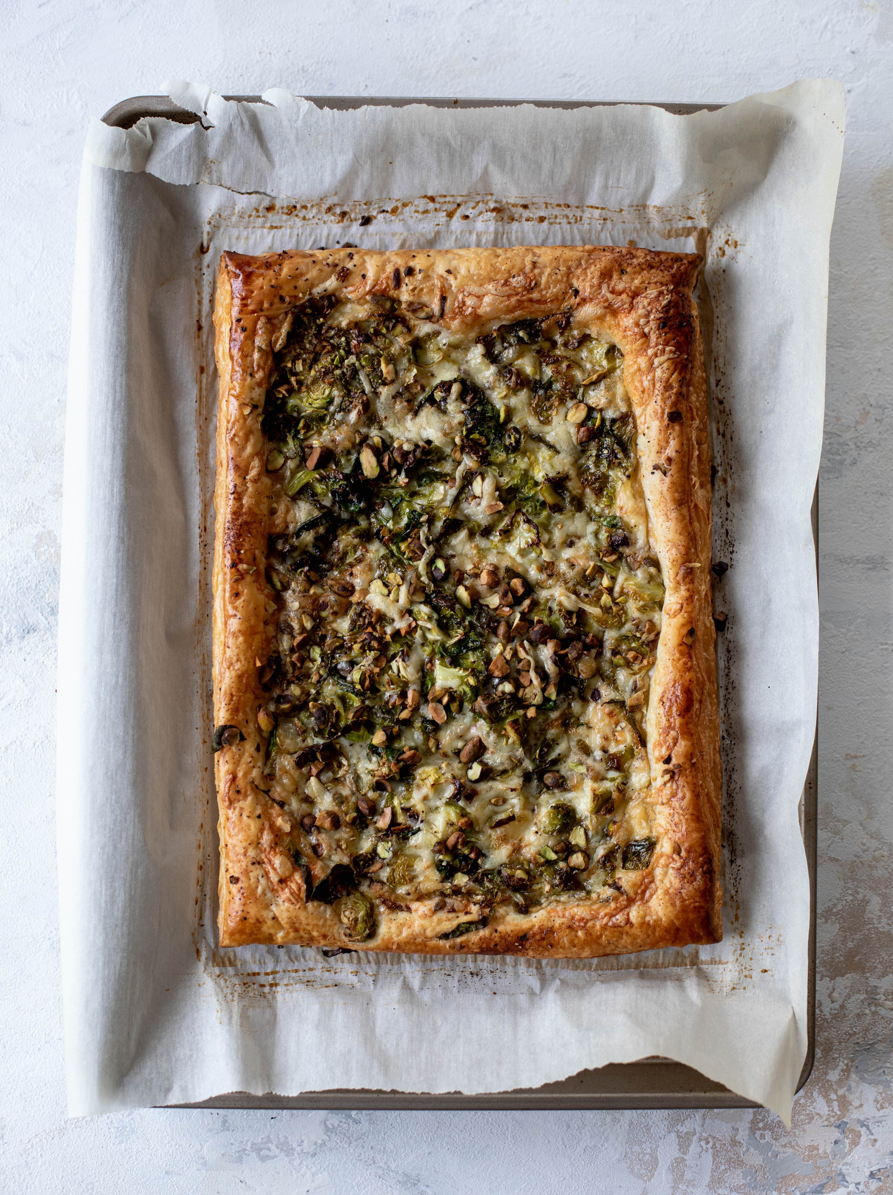 This brussels sprouts tart has a ton of flavor! Melty fontina, sliced brussels and crunchy pistachios all on top of puff pastry. Delish!