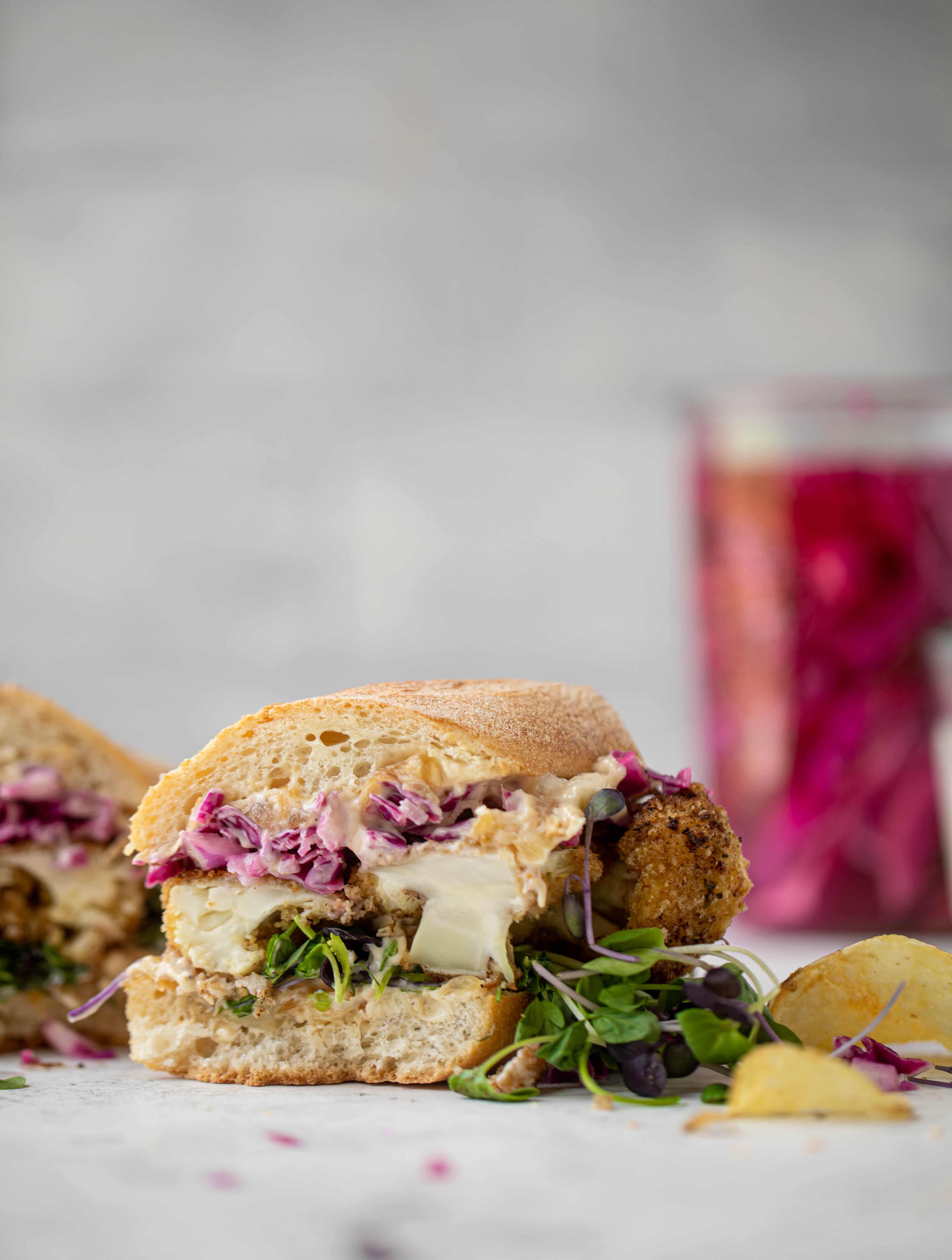 These cauliflower schnitzel sandwiches are full of flavor! Crispy cauliflower, caramelized onion mayo, pickled cabbage and microgreens. Delish!