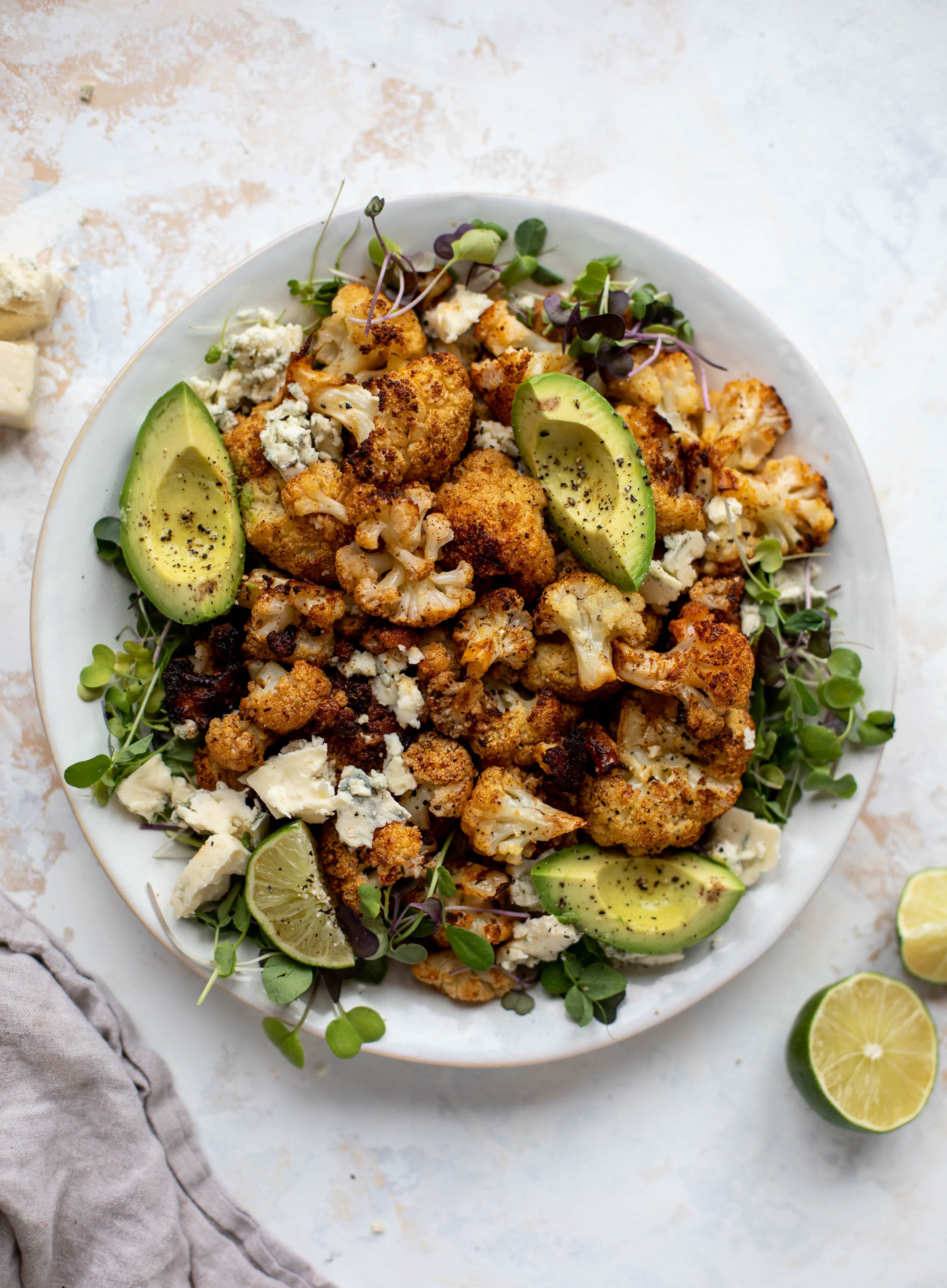 This crispy buffalo cauliflower is loaded with flavor! Serve with avocado and smoked blue cheese - you will want to eat this everyday!