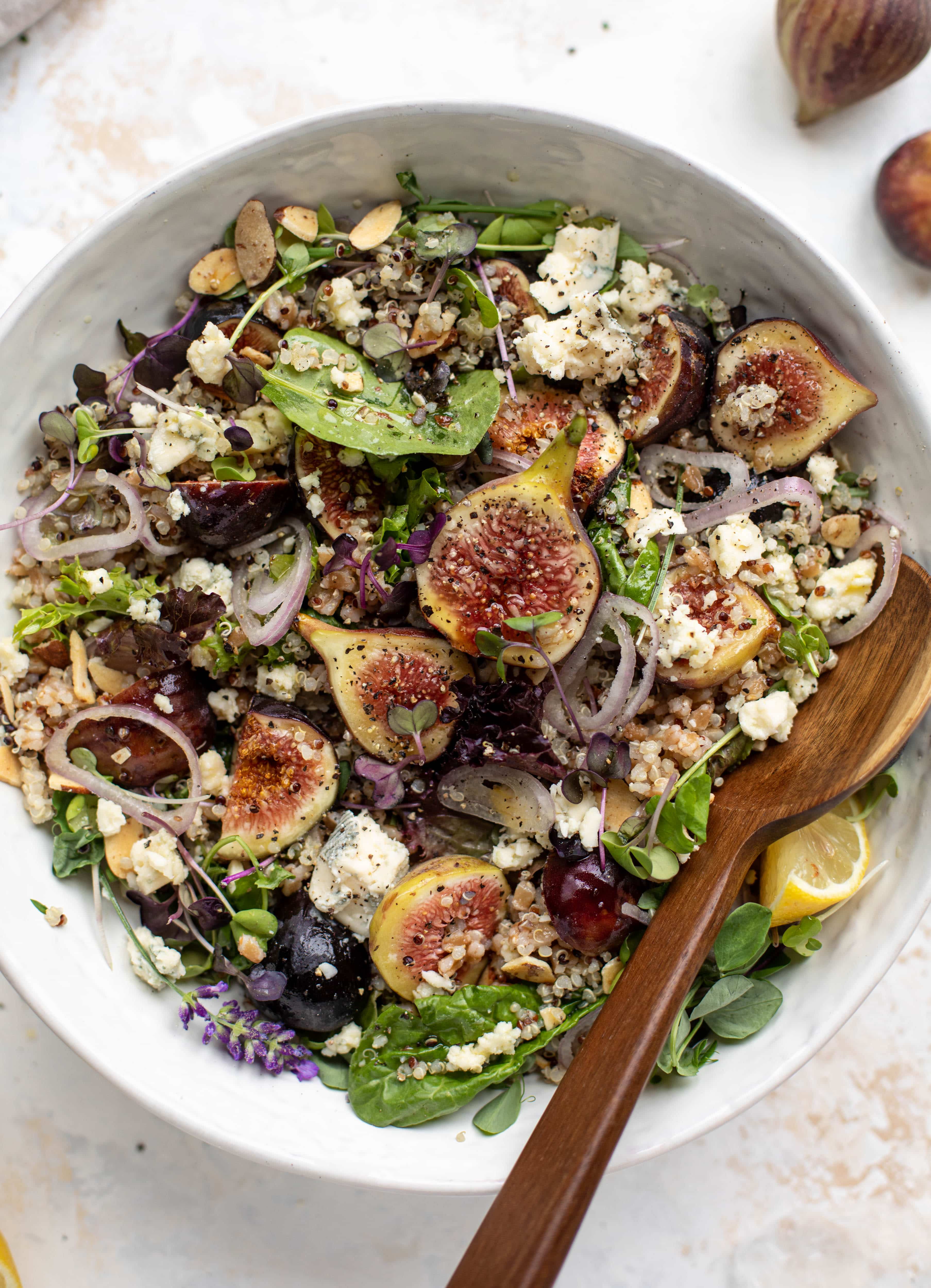 These grain bowls are the perfect September salad! Juicy figs, greens, quinoa, farro, almonds and a lemon lavender vinaigrette make this bowl irresistible. 