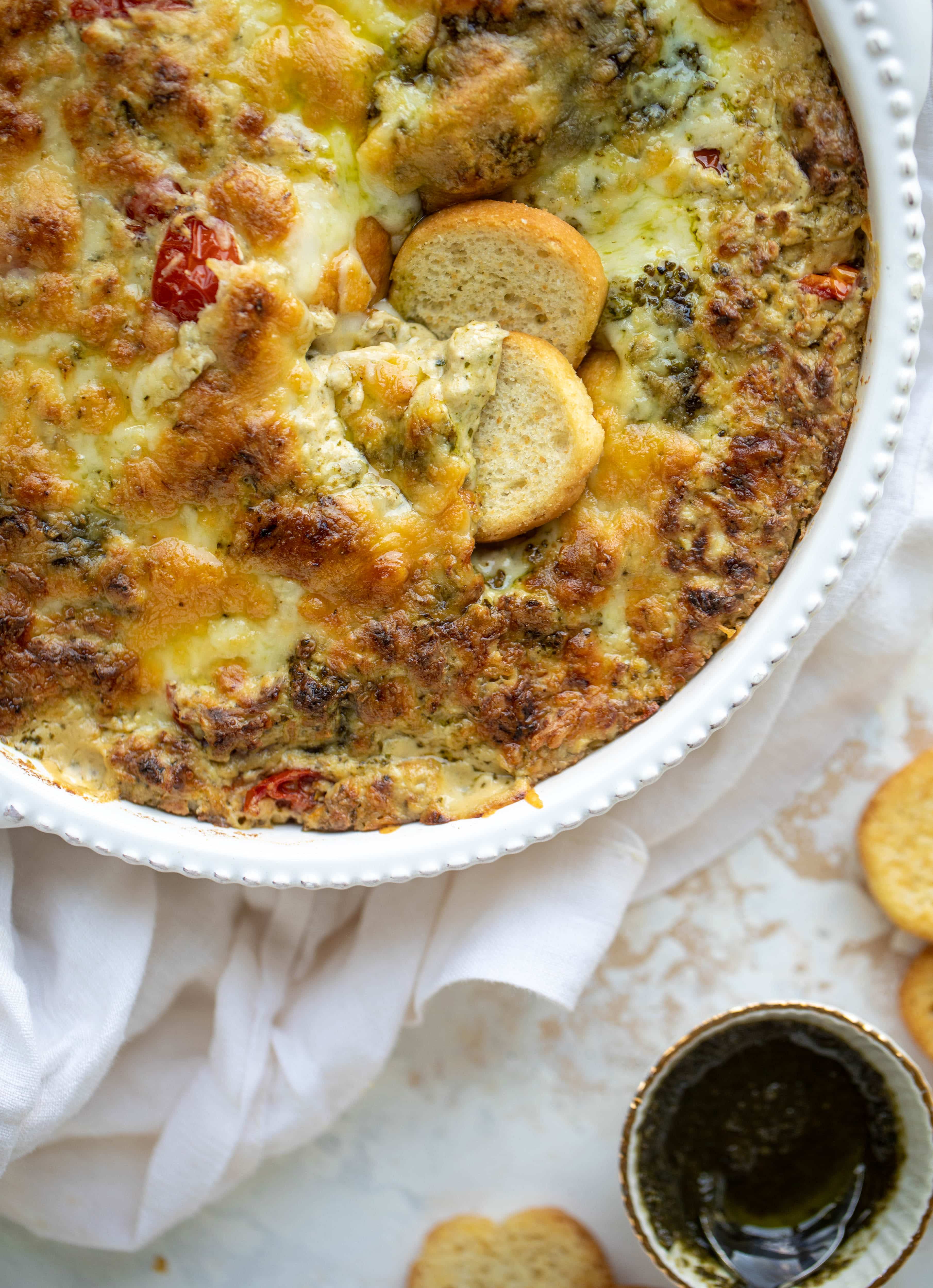 This cheesy pesto chicken dip is a great way to use up your end-of-summer herbs! Lots of delicious smoky flavor and tons of bubbly cheese.
