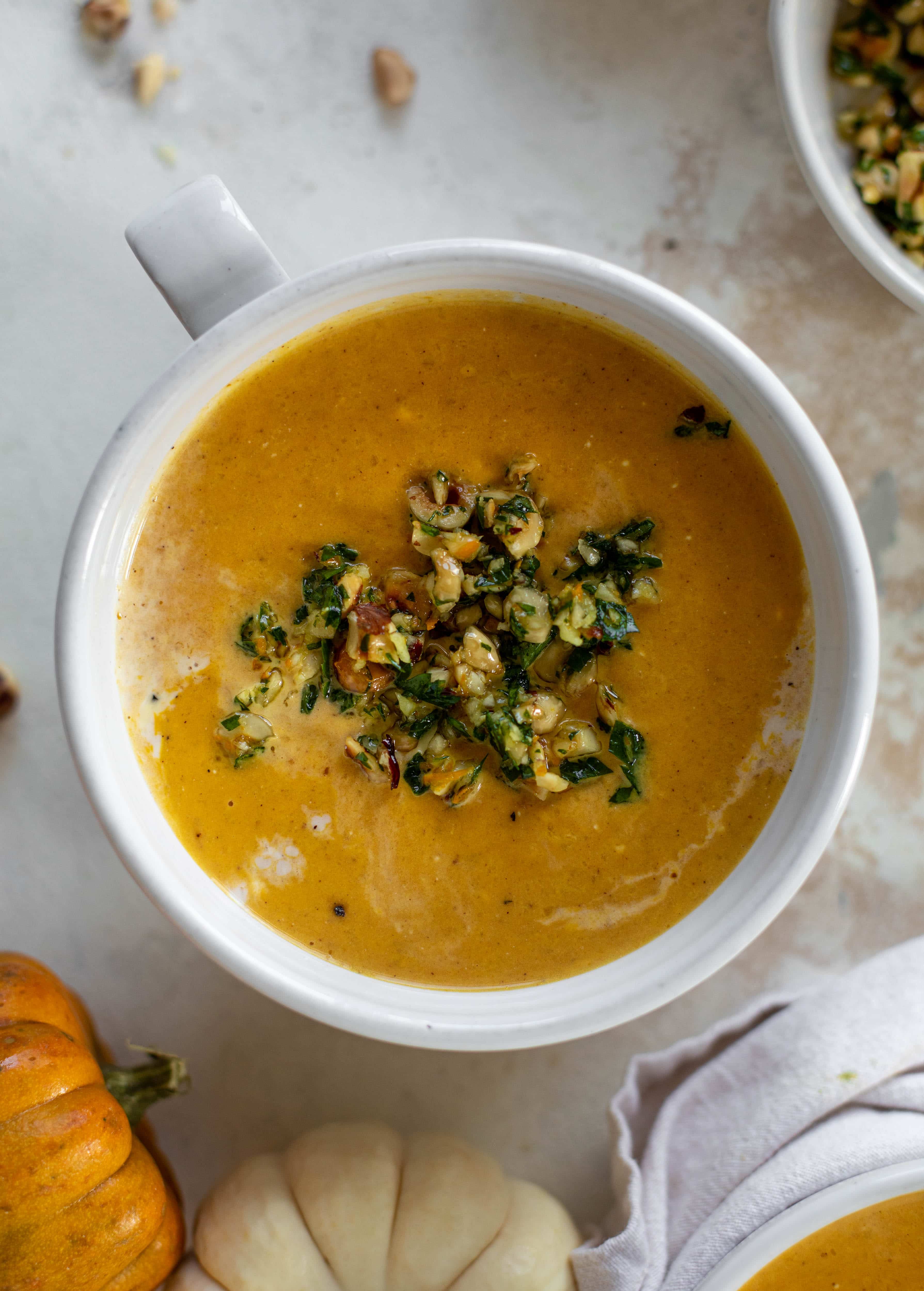 This pumpkin cream soup is silky smooth and delicious, then topped with a roasted hazelnut gremolata for extra flavor and crunch!