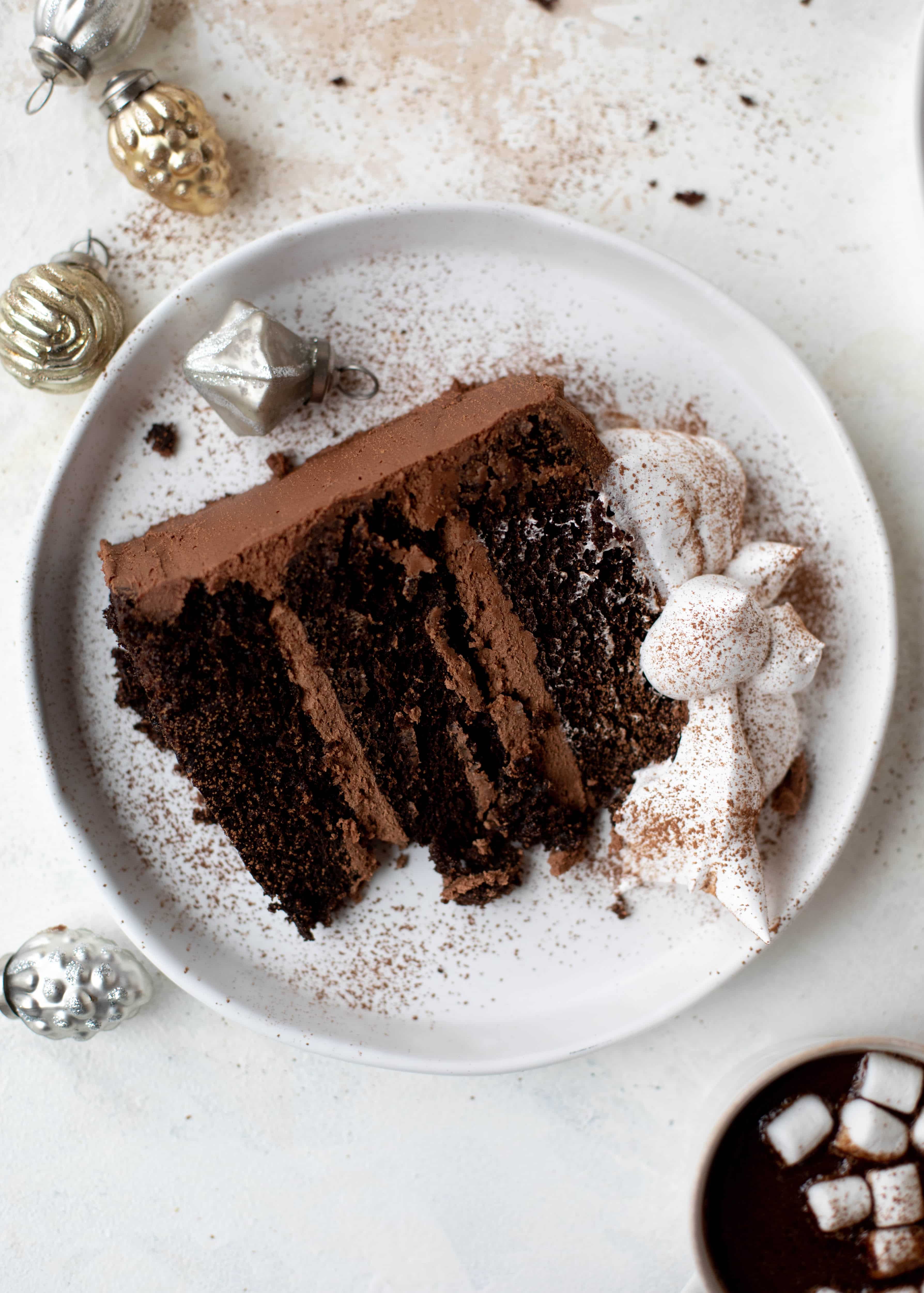 This hot cocoa cake is made with the fudgiest chocolate cake, smothered in chocolate cream cheese frosting and dolloped with whipped marshmallow!