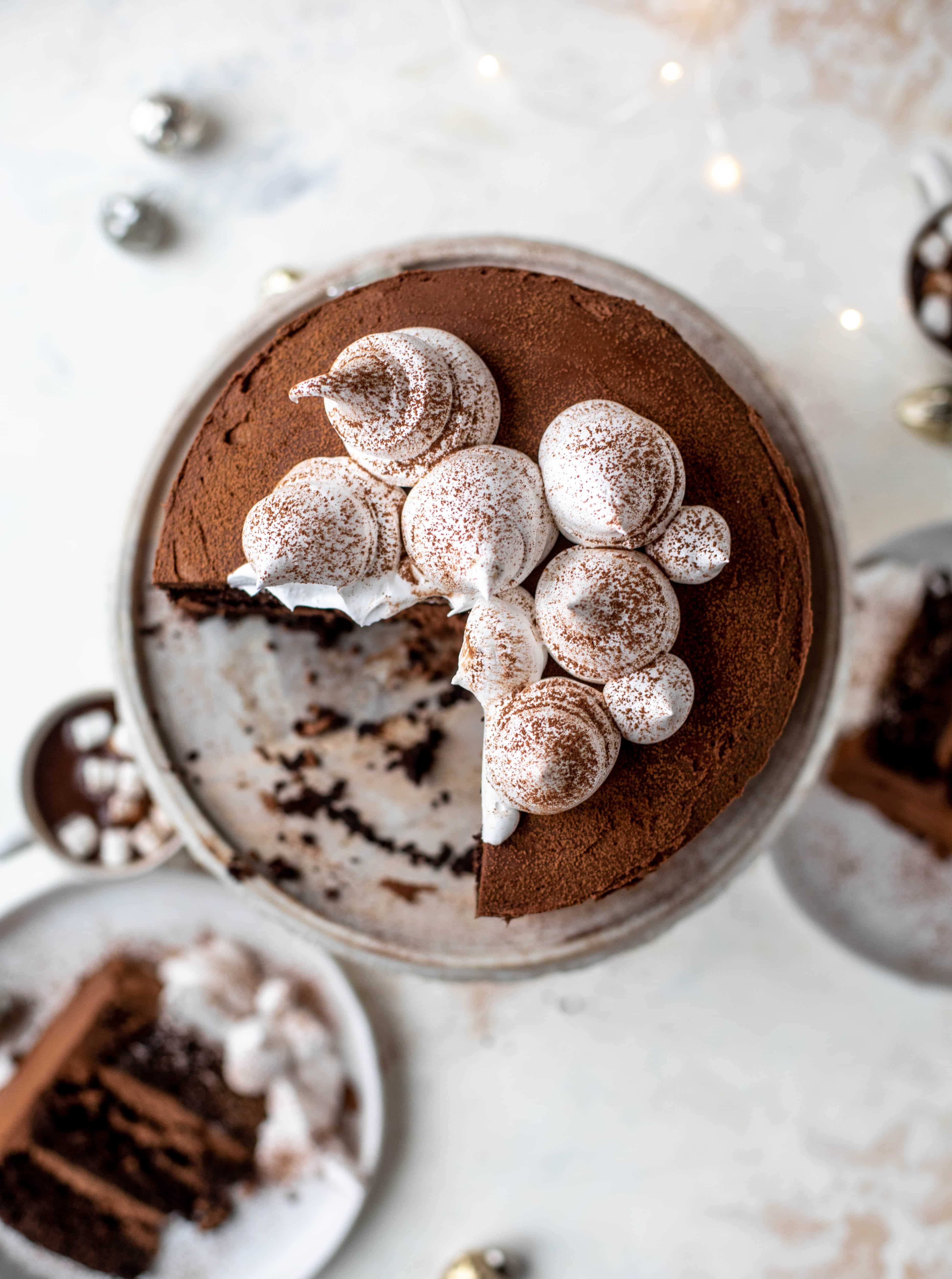 This hot cocoa cake is made with the fudgiest chocolate cake, smothered in chocolate cream cheese frosting and dolloped with whipped marshmallow!