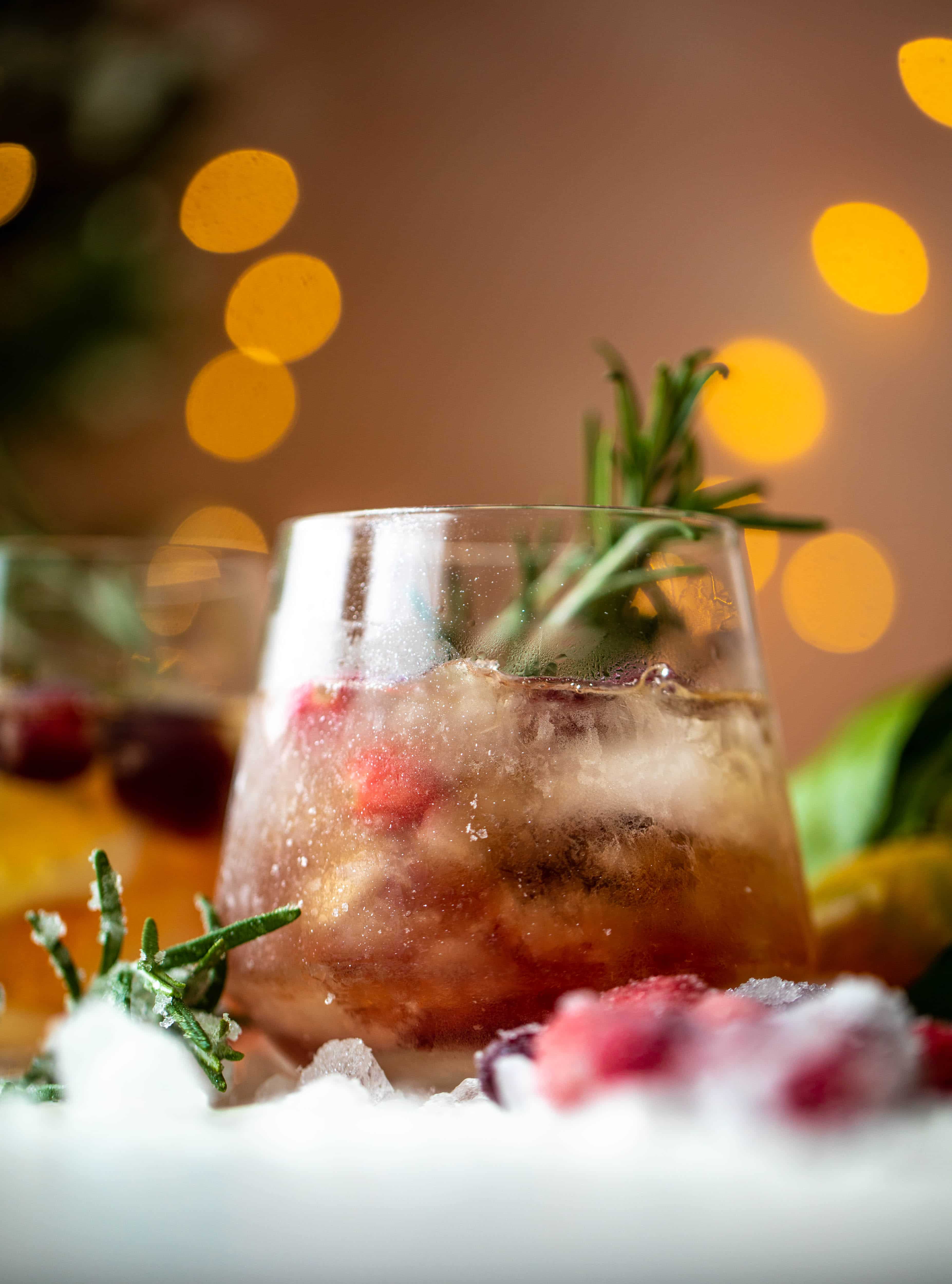 The mistletoe manhattan is a fun holiday spin on the classic manhattan cocktail! Sugared cranberries and rosemary make this super festive.