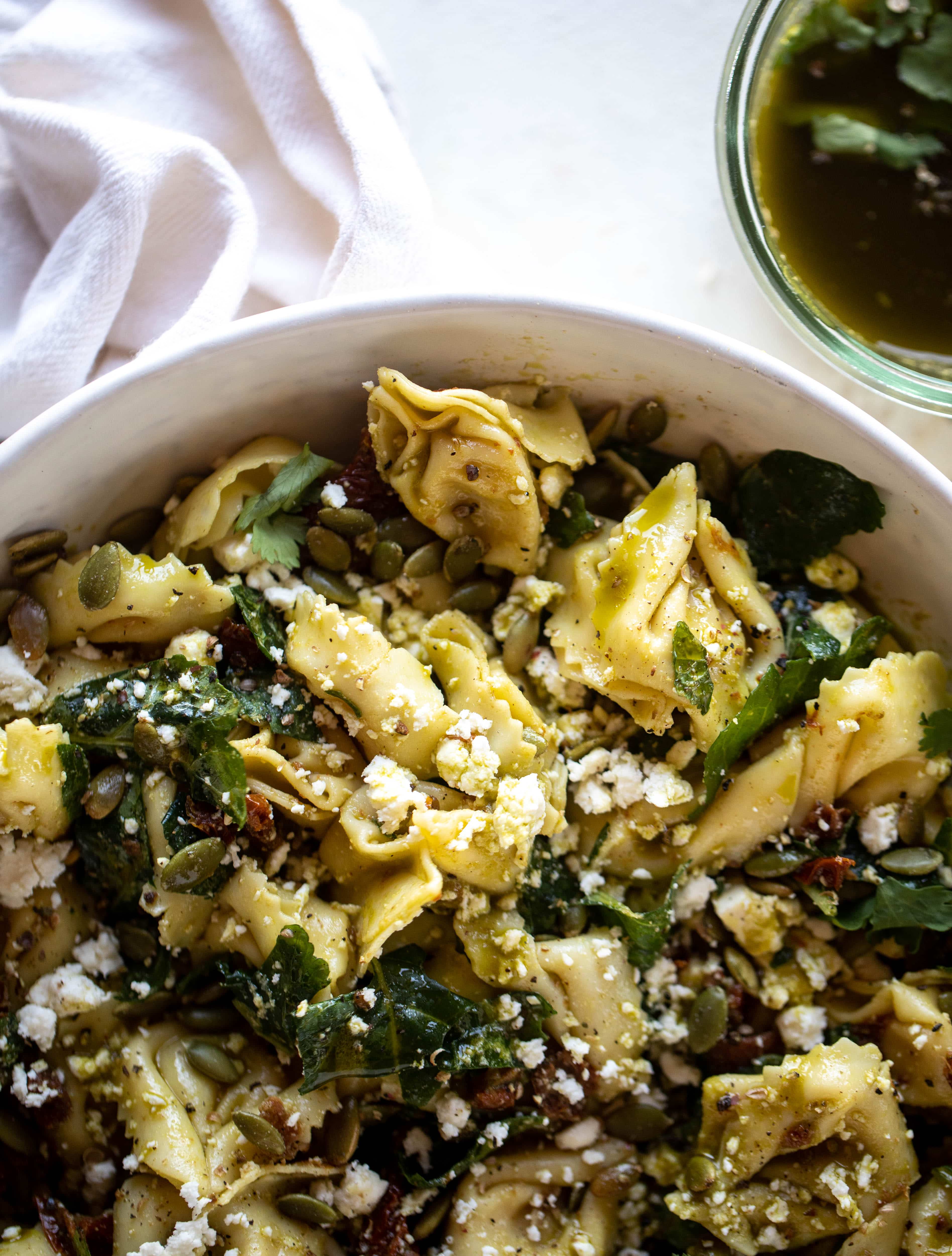 This cilantro lime tortellini salad is loaded with flavor! Served warm or cold, it has pepitas, sun dried tomatoes and crumbled feta. It's ridiculously good! 