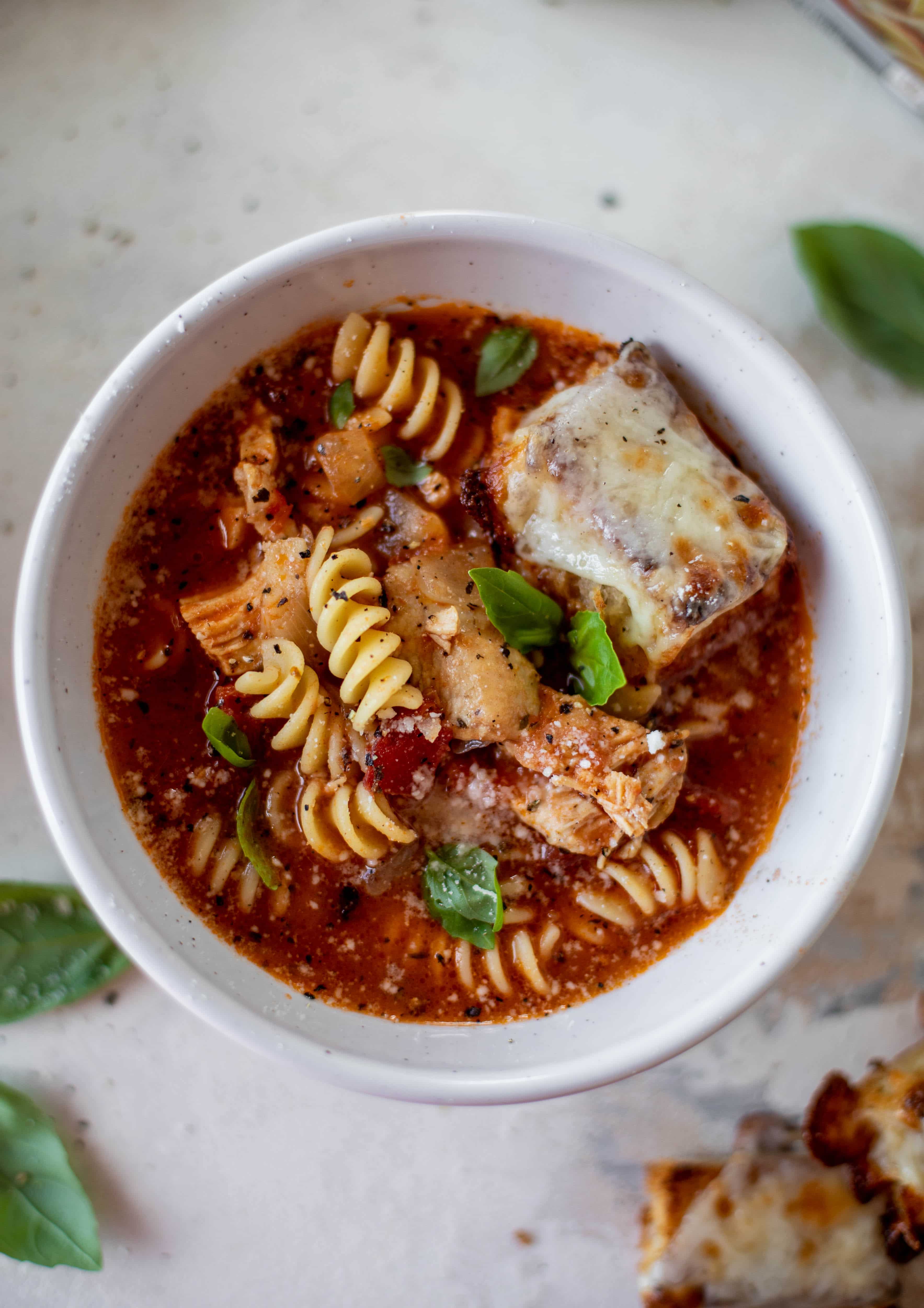 This chicken parmesan soup is ridiculously flavorful and so easy to make! Juicy chicken with pasta, fire roasted tomatoes and mozzarella croutons. Yum! 