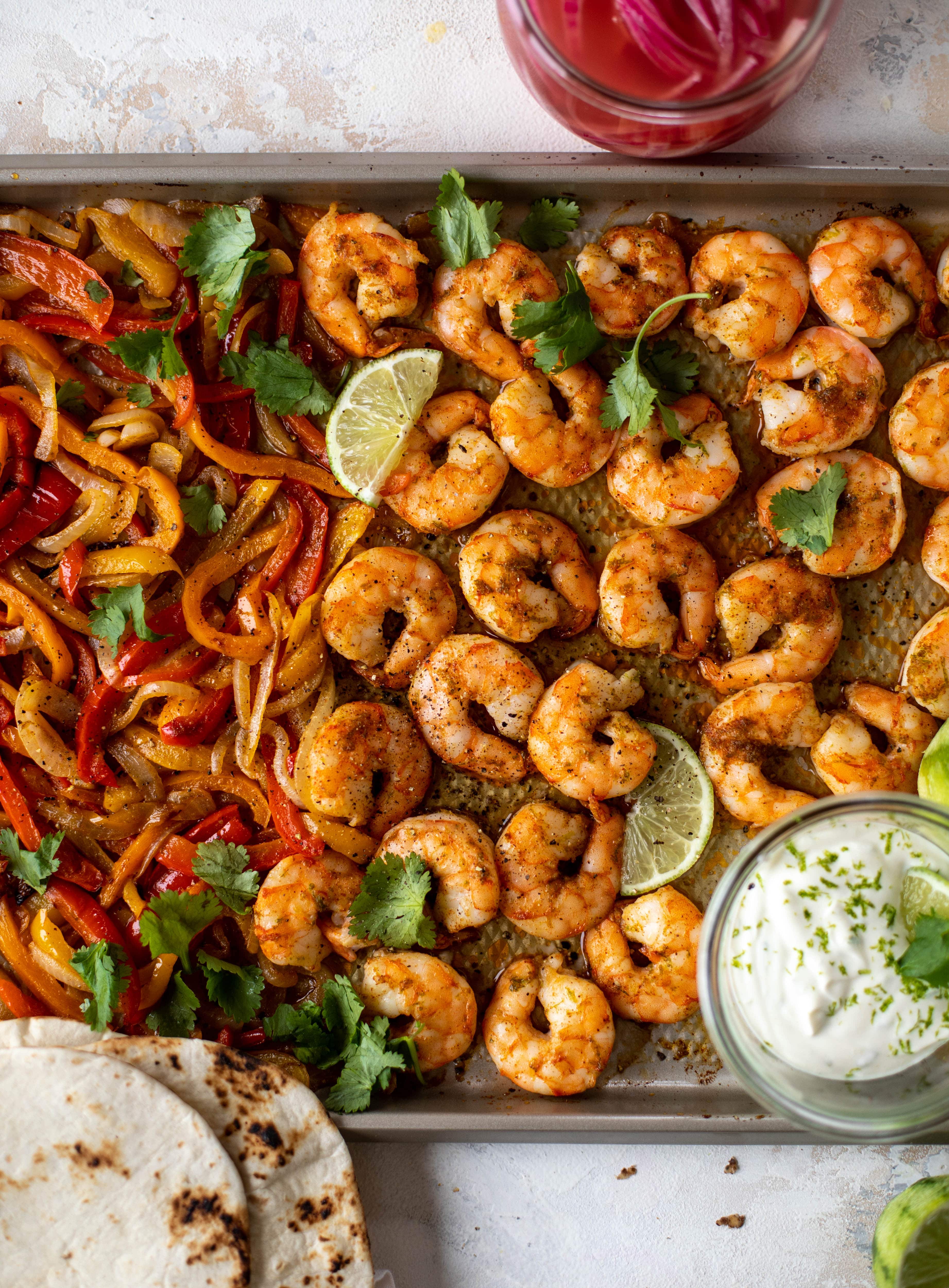 These lime sheet pan shrimp fajitas are the best weeknight meal! Make everything on the sheet pan and serve in warm tortillas. Delicious!