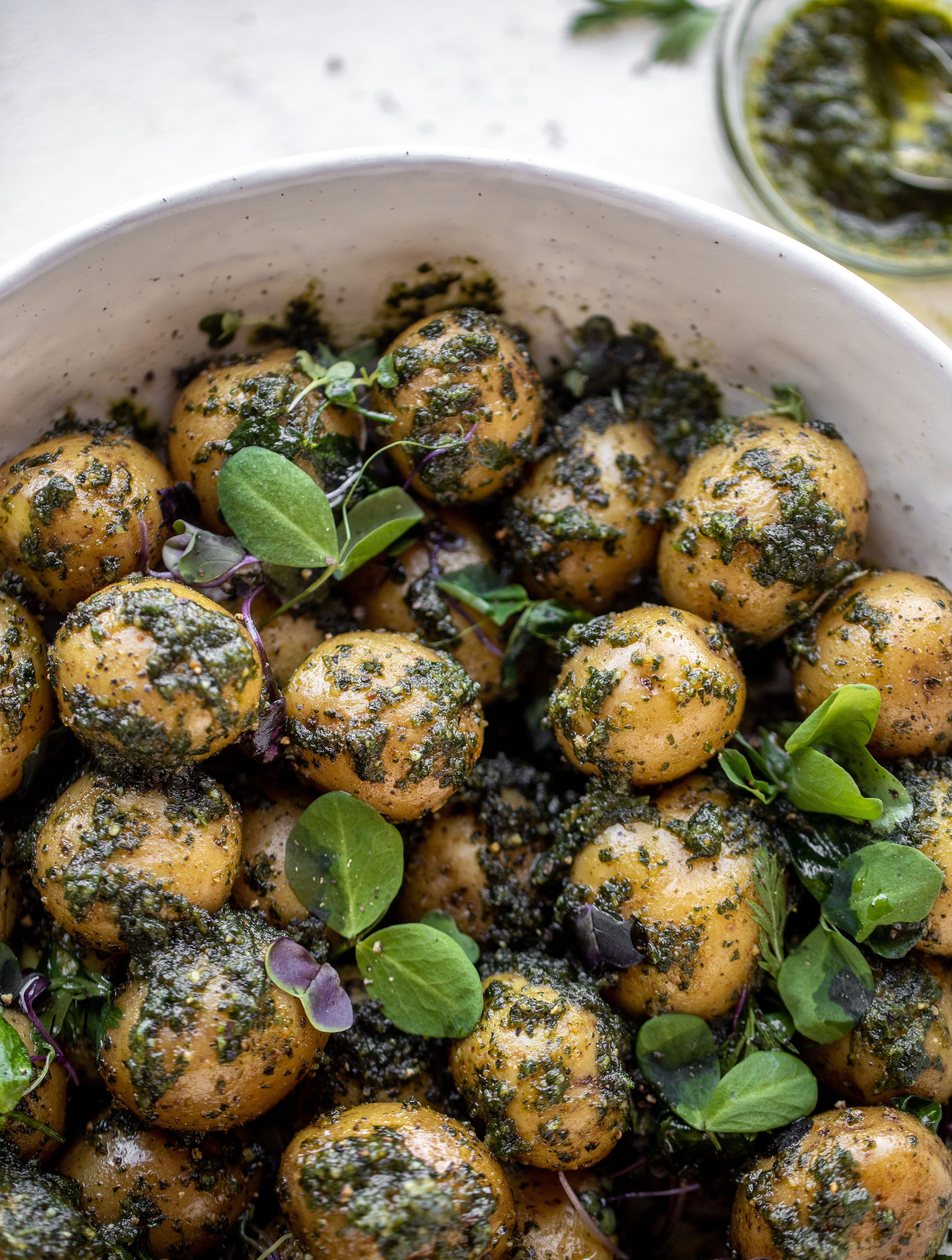 This pesto potato salad is made with carrot top pesto for the perfect spring side dish! Baby potatoes, pesto and greens make up this delish bowl.