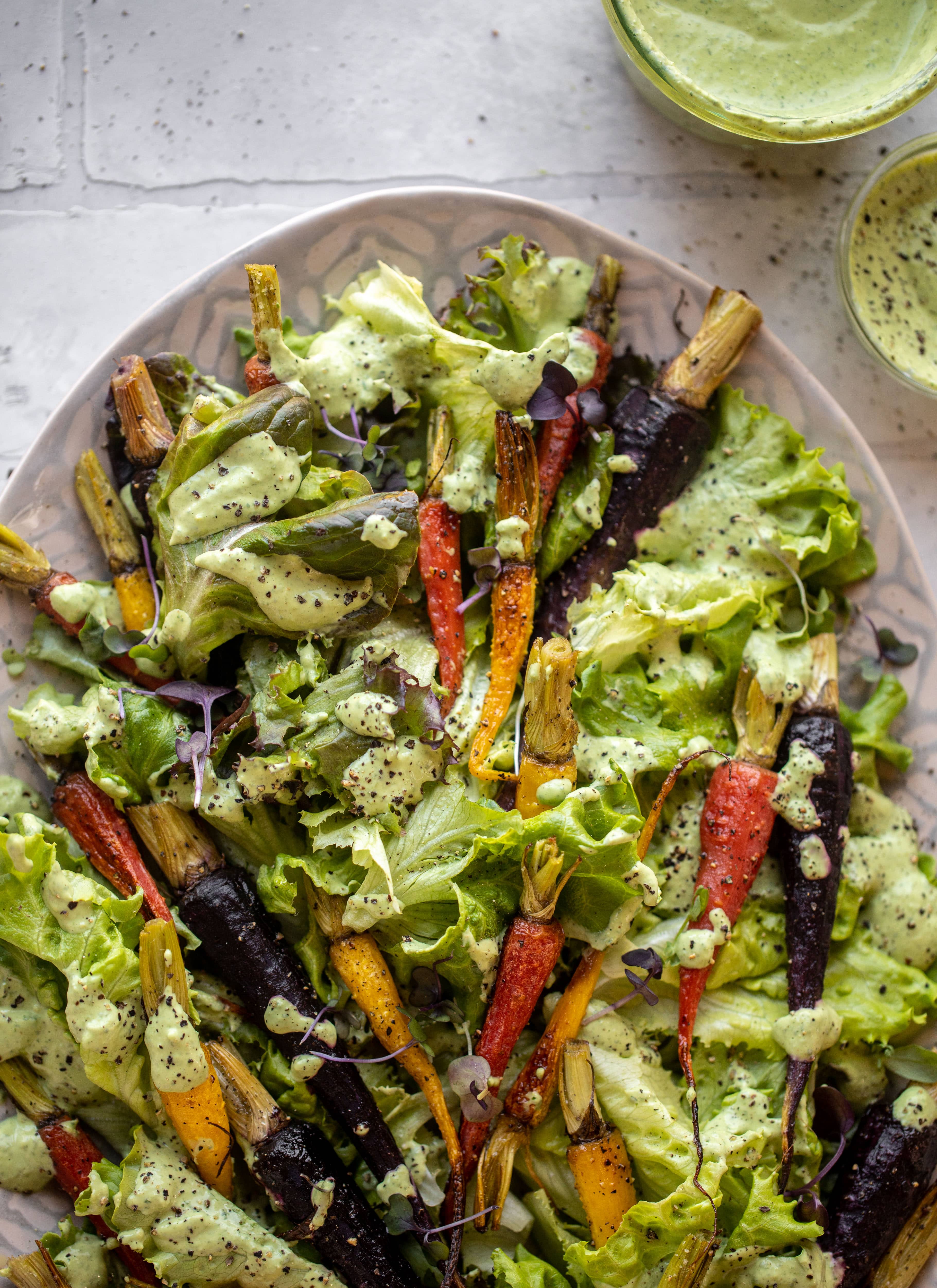 This roasted carrot salad is perfect for spring! Caramely, roasted carrots served over butter greens dressing with green goddess. Simple but delish.