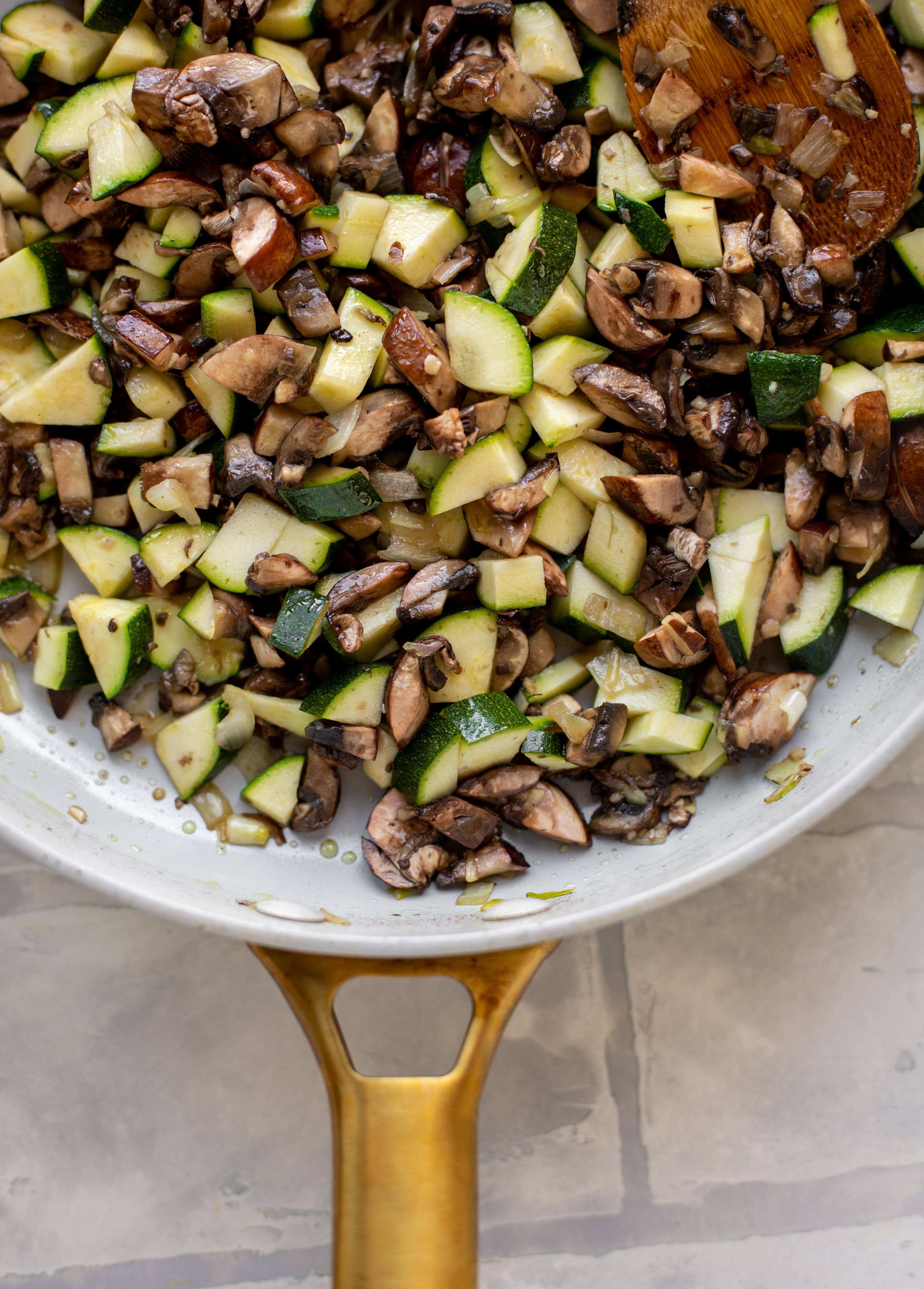 zucchini, mushrooms and onions in a skillet