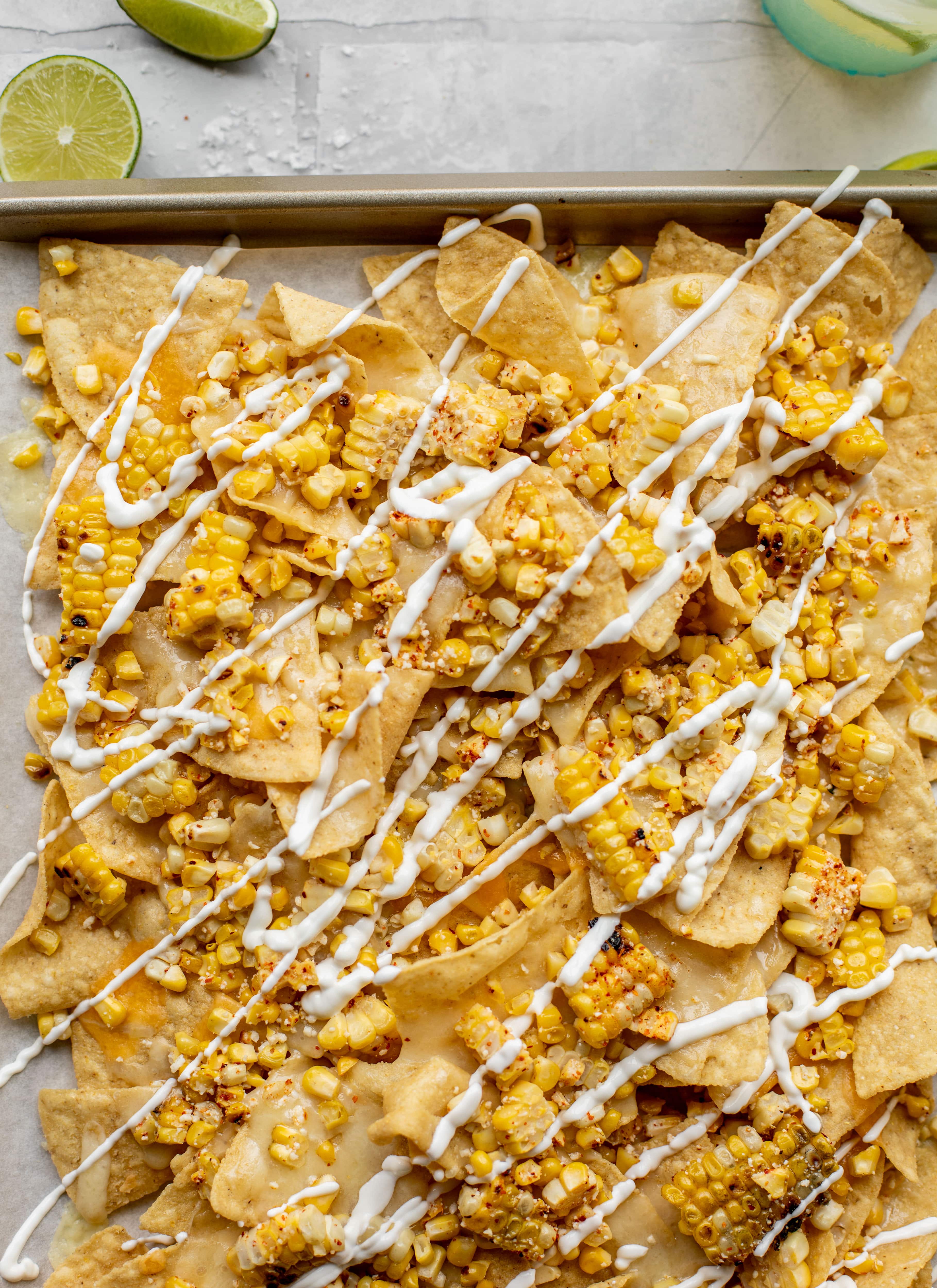 These sheet pan street corn nachos are ridiculously easy and delicious! Grilled corn, chili, lime, tons of cheese and all the flavor you could dream of!