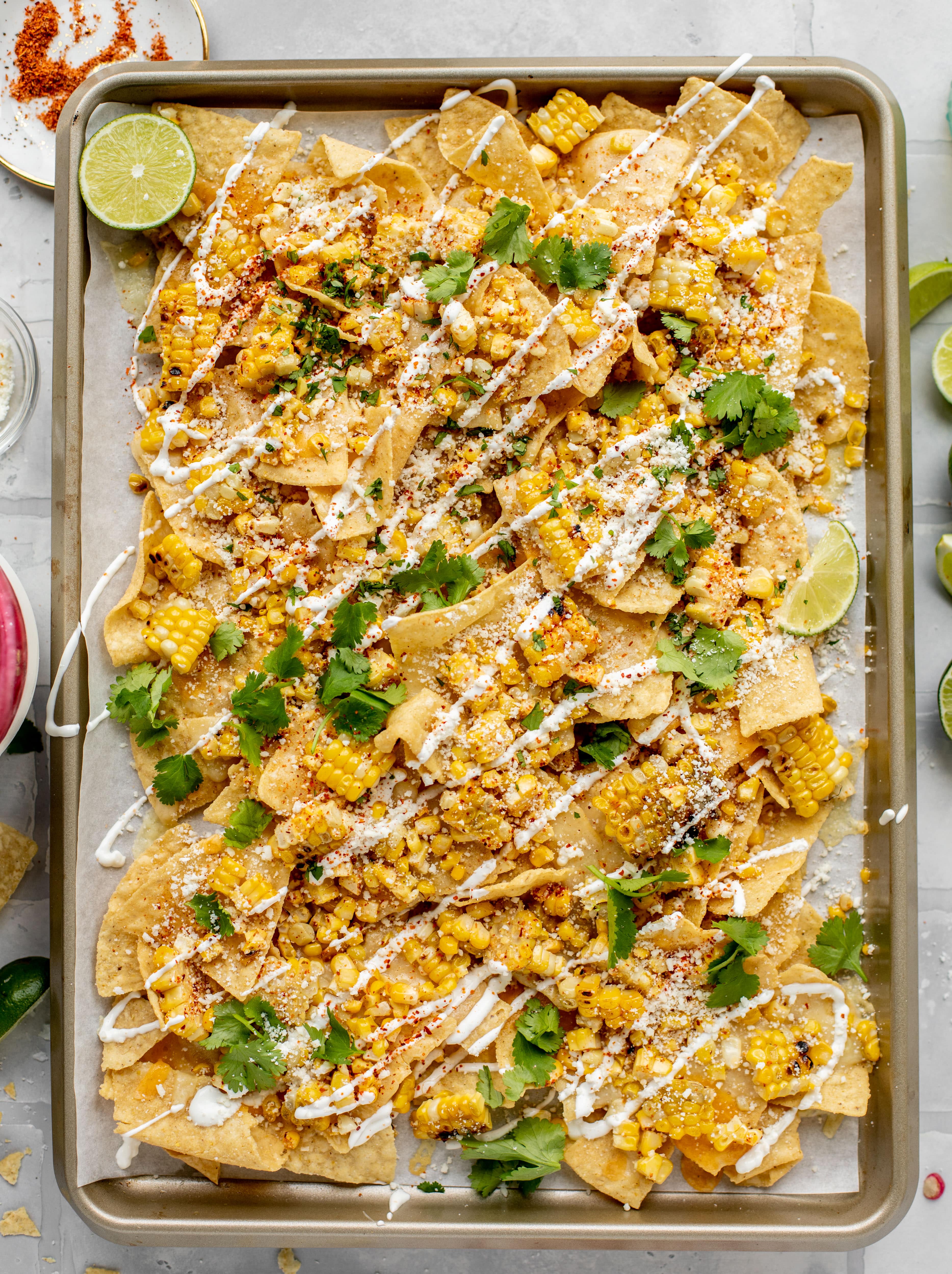 These sheet pan street corn nachos are ridiculously easy and delicious! Grilled corn, chili, lime, tons of cheese and all the flavor you could dream of!