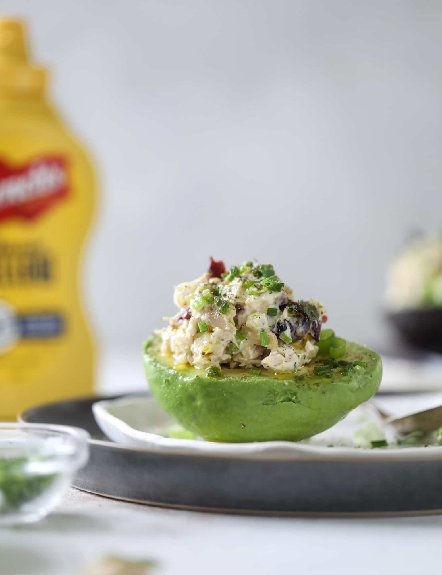 These smoky chicken salad stuffed avocados are lunchtime gold! They are super easy to throw together, satisfying and pretty darn great for you. Made with greek yogurt, some tangy mustard and dried cherries for sweetness, they are delish! I howsweeteats.com #chicken #salad #stuffed #avocados #greekyogurt