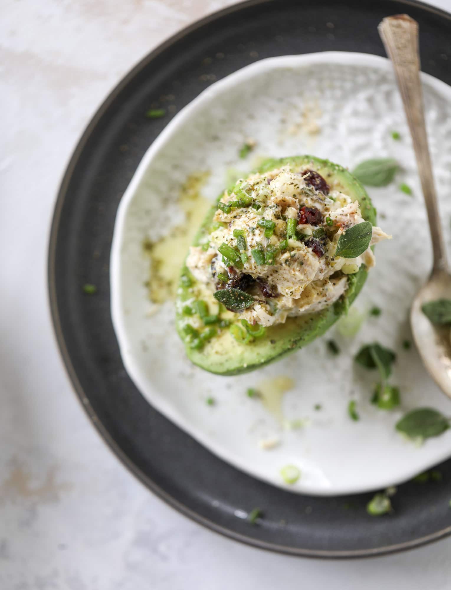 These smoky chicken salad stuffed avocados are lunchtime gold! They are super easy to throw together, satisfying and pretty darn great for you. Made with greek yogurt, some tangy mustard and dried cherries for sweetness, they are delish! I howsweeteats.com #chicken #salad #stuffed #avocados #greekyogurt