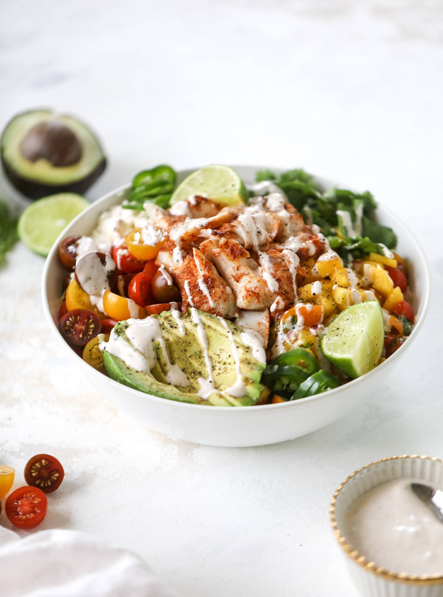 These fish taco bowls are an amazing weeknight meal idea! Napa cabbage for the base, a homemade chipotle crema, avocado, mango pico de gallo, spicy broiled white fish and lots of lime. Major flavor explosion and so easy too! I howsweeteats.com #fish #taco #bowls #spicy #healthy #dinner