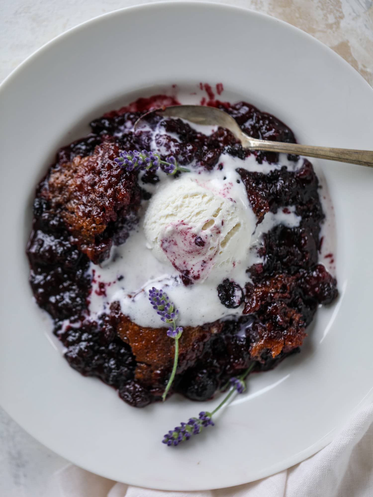 This black raspberry cobbler is a summer dream come true! The bursting black raspberries are rich and sweet, then add in a touch of lavender for incredible flavor and you're all set. The cobbler cake topping is perfect for vanilla ice cream. Win! I howsweeteats.com #black #raspberry #cobbler #lavender #summer #desserts #icecream