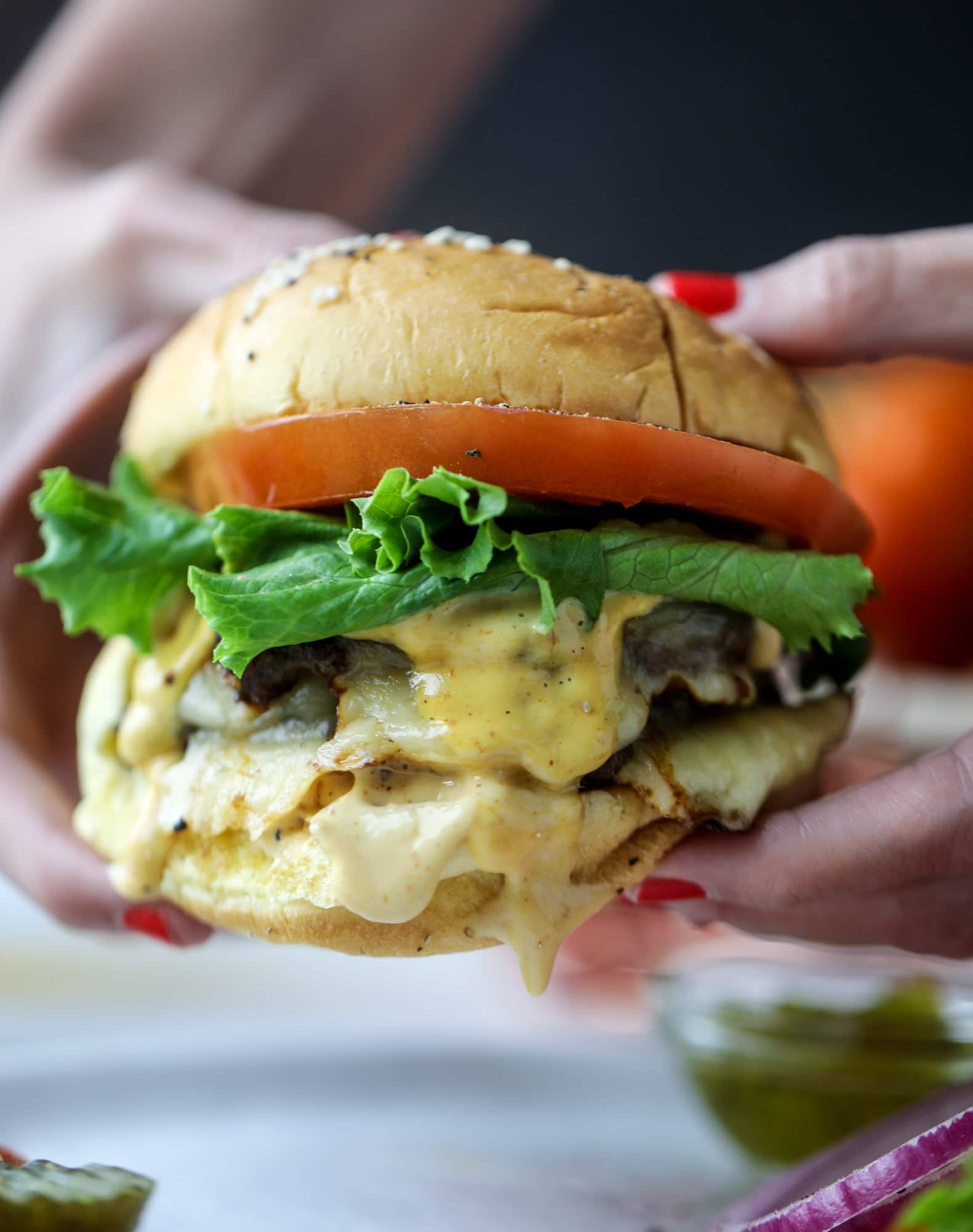 These smash burgers are to die for! All you need are a few ingredients and 30 minutes to make these smash burgers happen. Topped with melty smoked gouda and topped with a creamy, tangy house sauce, these are the best burgers ever! I howsweeteats.com #smash #burgers #smoked #gouda #special #sauce