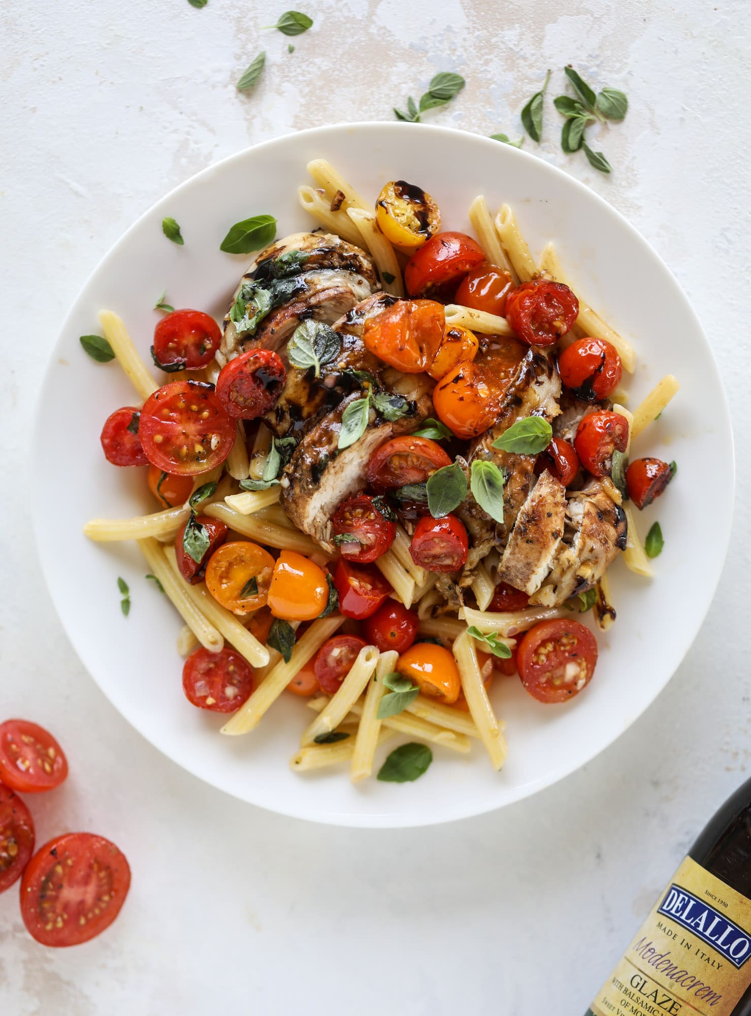 This bruschetta chicken is the perfect summer garden meal! Juicy, flavorful chicken topped with fresh tomatoes, garlic, basil and balsamic glaze, along with a touch of cheese. Served with pasta, it's an incredible meal. I howsweeteats.com #bruschetta #chicken #pasta #tomatoes #basil 