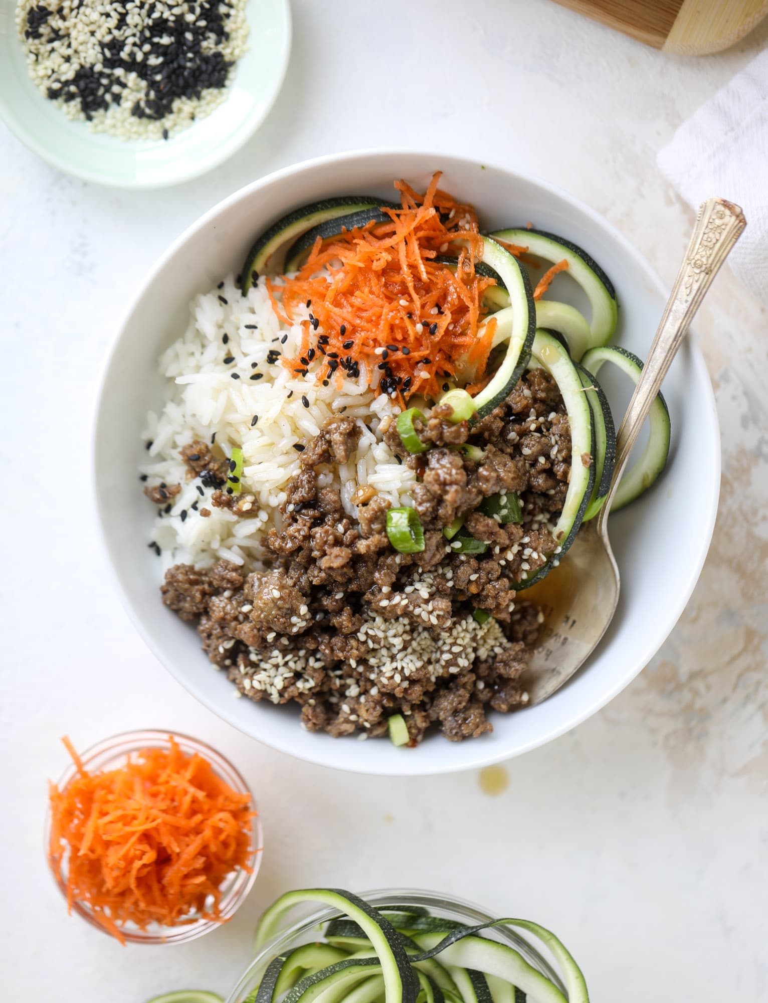 These korean beef bowls are so packed full of flavor that you won't want to eat anything else! Serve the beef with zucchini noodles, grated carrot and jasmine rice for a satisfying, flavor-packed bowl that comes together easily and quick! I howsweeteats.com #korean #beef