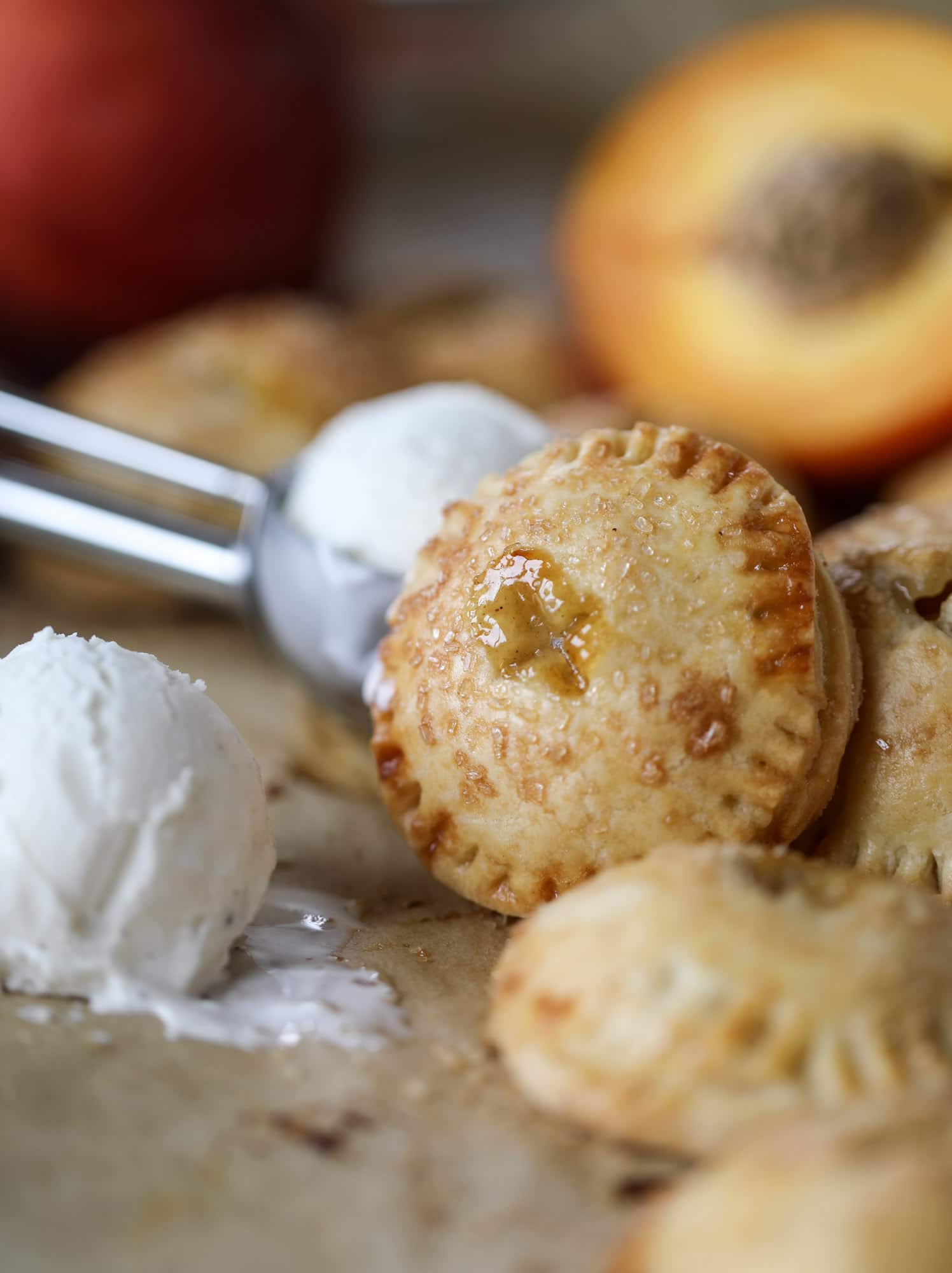 These little peach hand pies are super easy to make and oh-so delicious for summer! A warm and syrupy homemade peach filling made with brown sugar and bourbon, stuck inside a flakey all-butter crust and sprinkled with coarse sugar. SO GOOD. I howsweeteats.com #peach #hand #pies #mini #dessert #summer