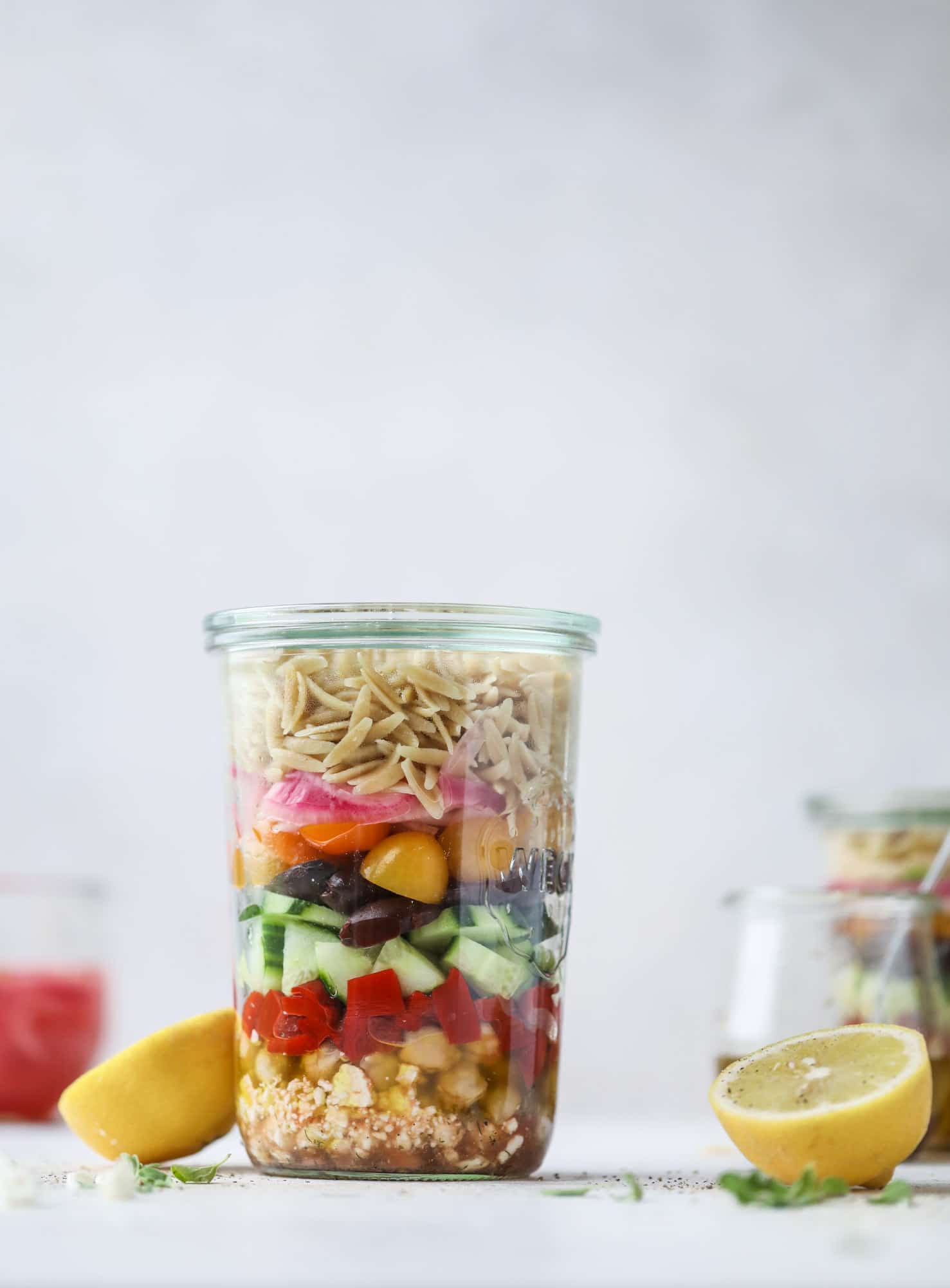 This incredible greek orzo salad in a jar is to die for! The recipe is so easy and flavorful, super satisfying and perfect for meal prep. This salad in a jar is a delicious lunch idea for the weekdays and keeps you feeling full and happy! I howsweeteats.com #salad #jar #greek #orzo #recipes #healthy #lunch #mealprep