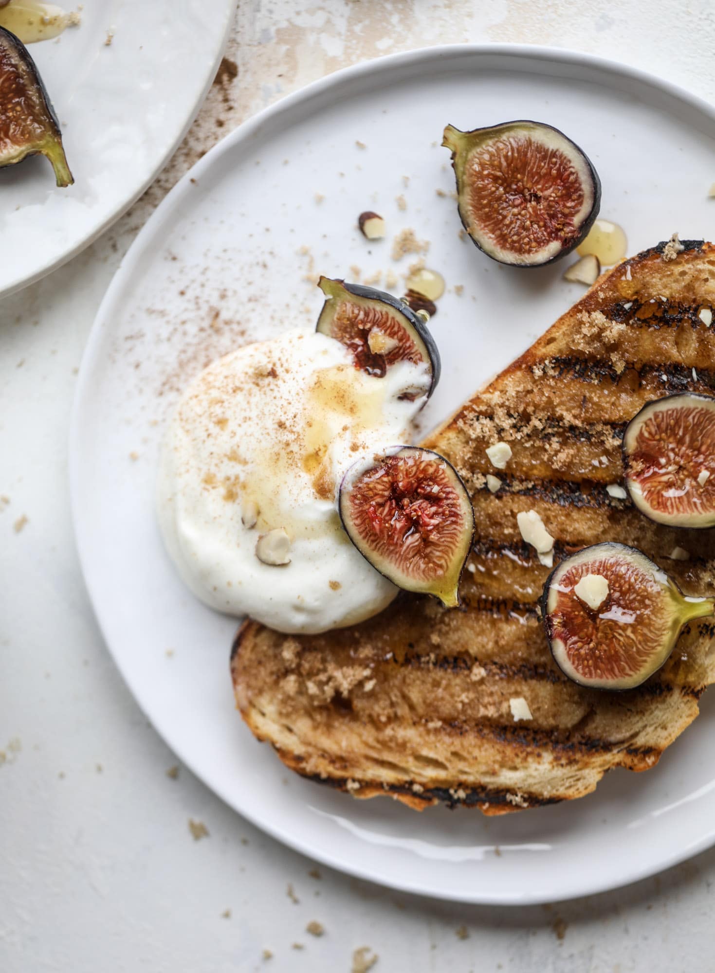 This cinnamon sugar toast is an absolutely dream! It's spread with a cinnamon brown sugar butter, grilled to perfection and served with creamy whipped ricotta cheese, fresh figs, honey, cinnamon and sliced almonds. I howsweeteats.com #cinnamon #sugar #toast #ricotta #figs #breakfast