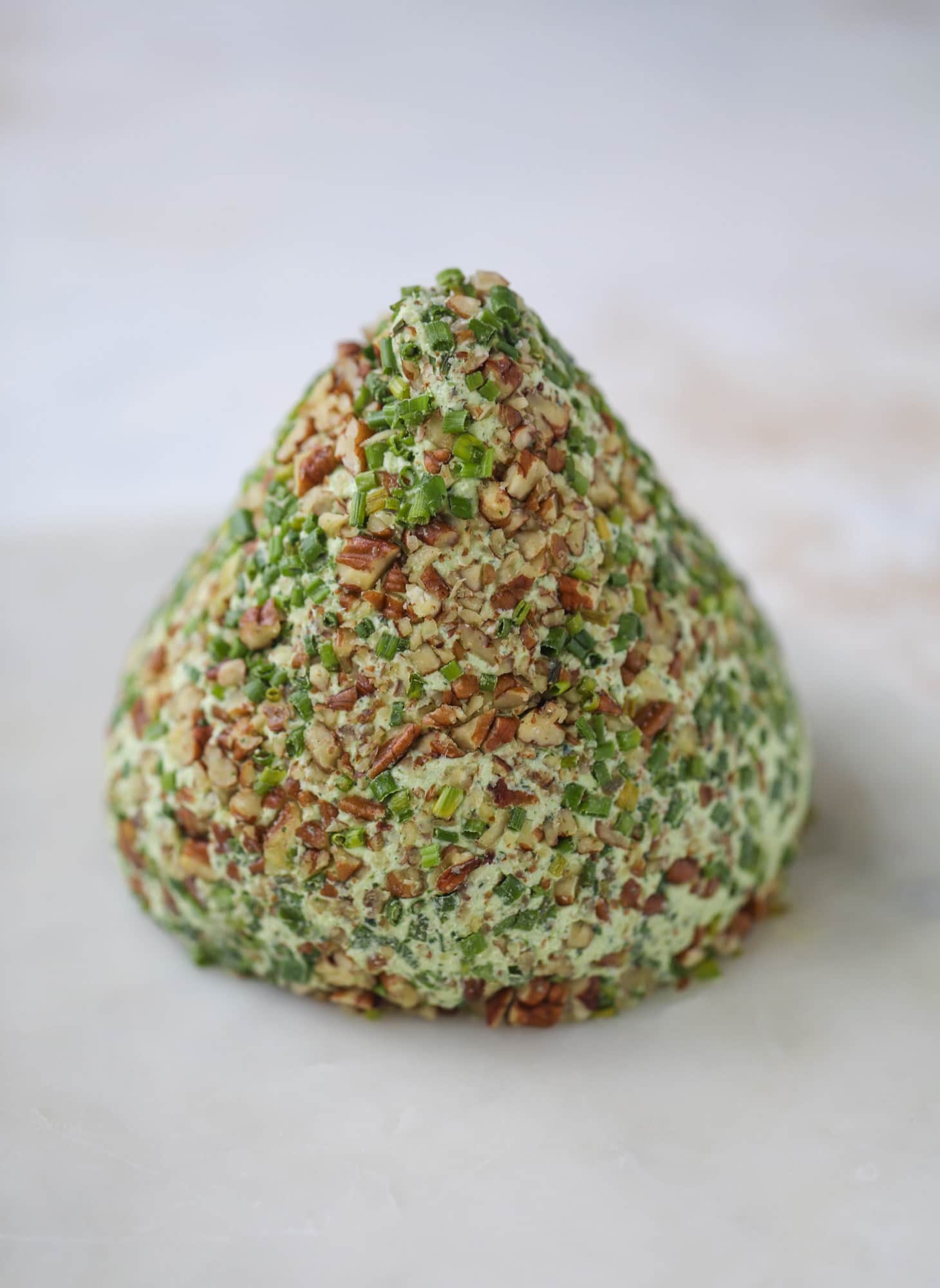 This green goddess cheese ball is the perfect party snack! You can make it ahead of time and shape it into a cute tree for a festive look. Serve it with crispy crackers and pita chips! I howsweeteats.com #greengoddess #cheeseball