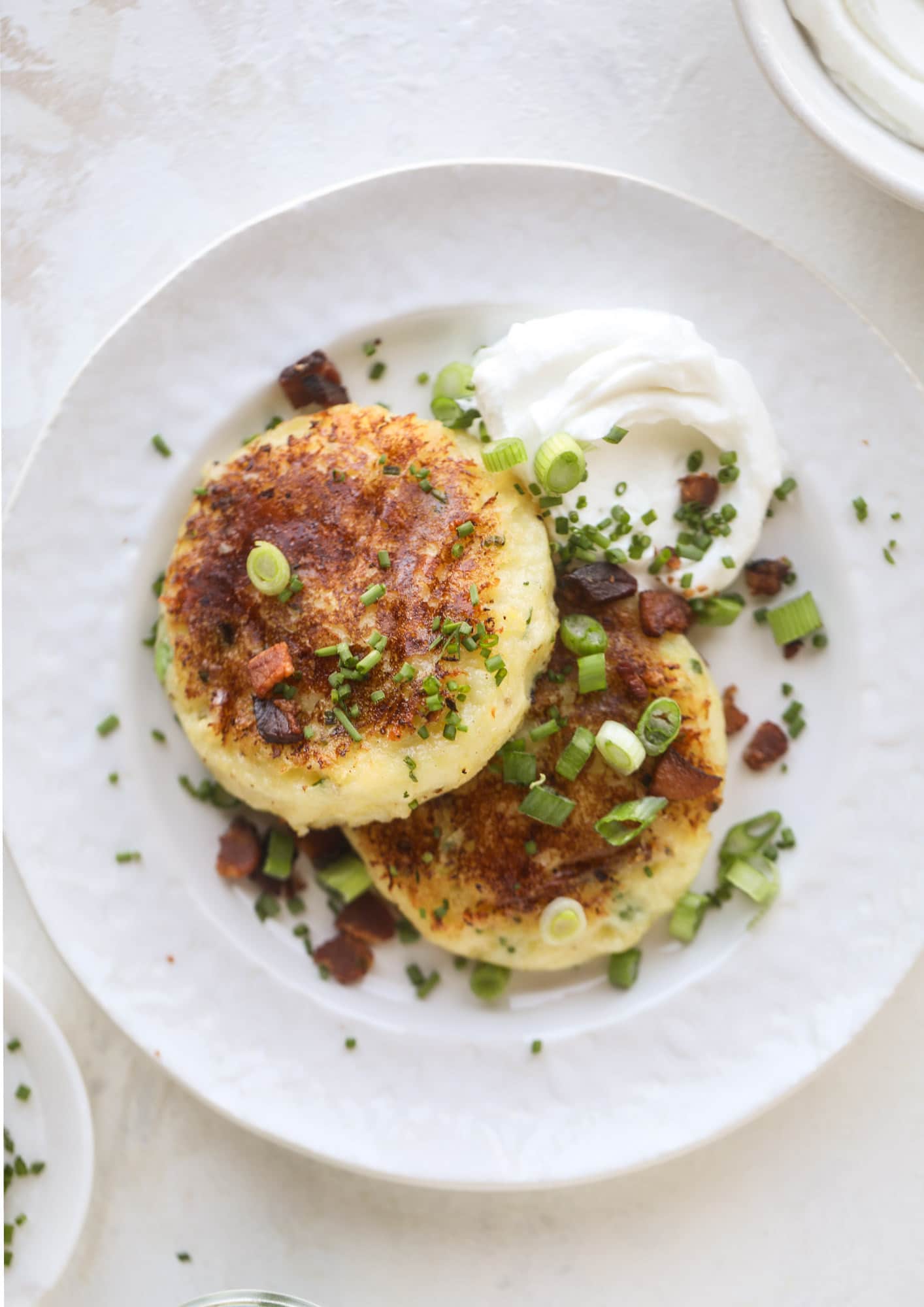 Loaded mashed potato pancakes are the perfect comfort food or side dish to a hearty meat. Crispy mashed potatoes with aged cheddar. Delicious! I howsweeteats.com #mashedpotato #pancakes