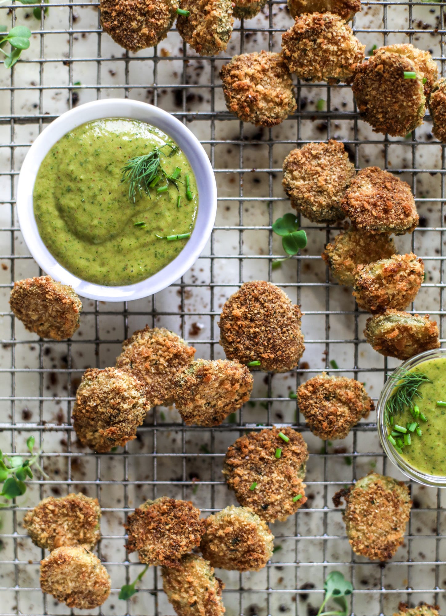 Oven fried crispy pickles are super crunchy and delicious! Served with a dairy free green goddess ranch dip, they are the best snack ever. 