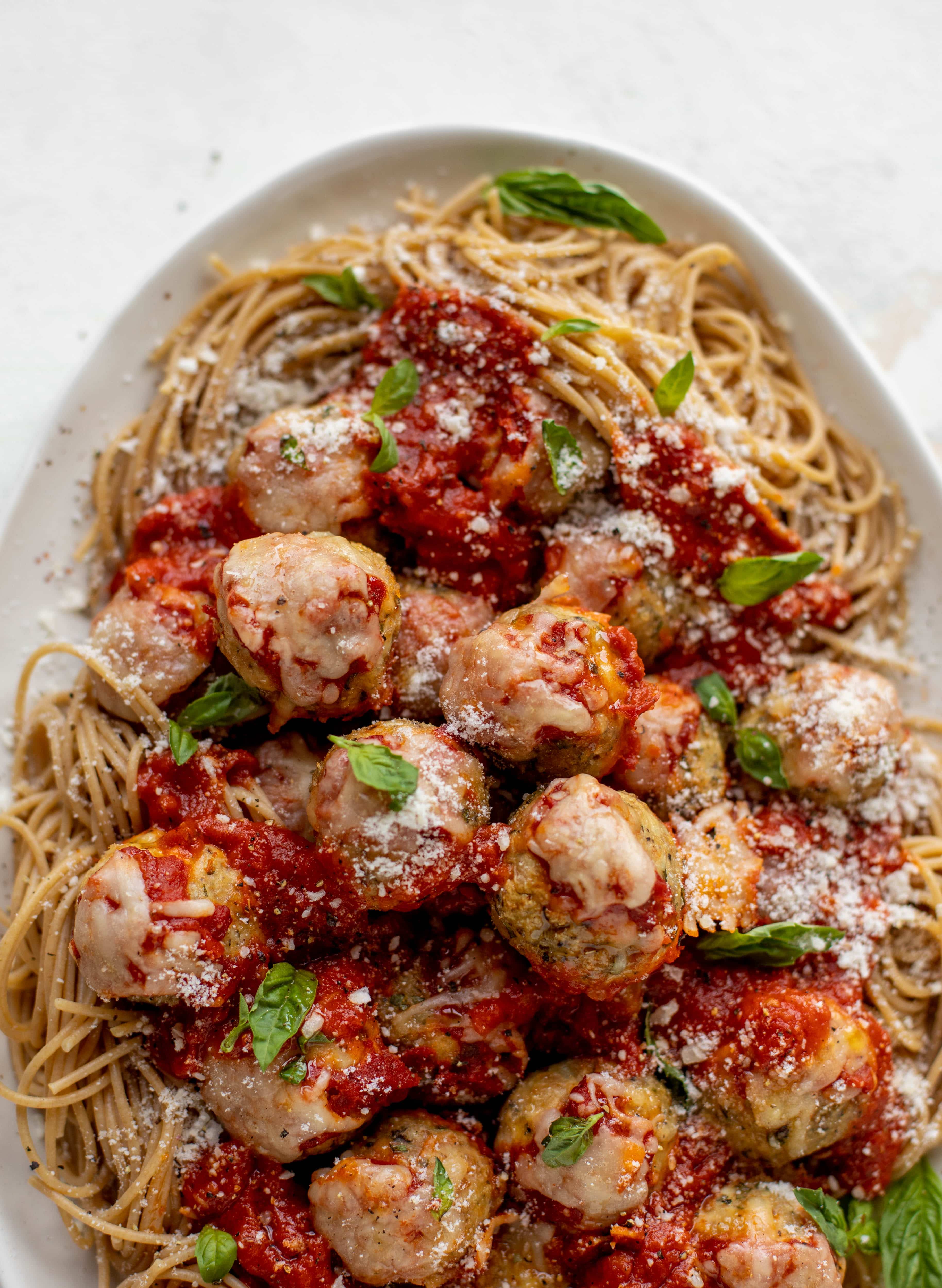 Chicken parmesan meatballs are baked and super flavorful! Serve with roasted garlic spaghetti for the best dinner ever! You can make them ahead of time too!