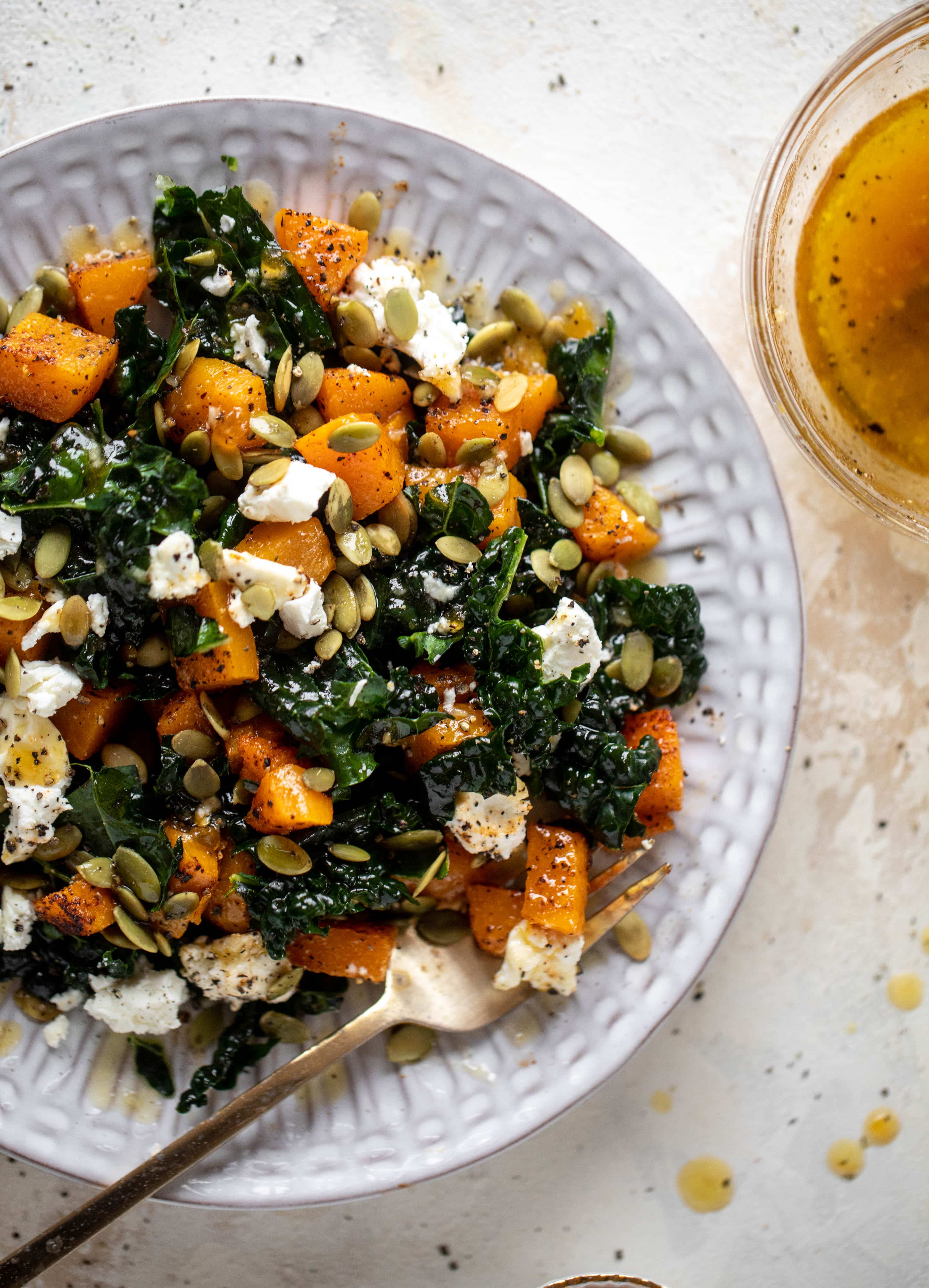 This butternut squash kale salad is so easy and delicious! Roasted, smoky butternut squash, goat cheese, pepitas and apricot vinaigrette.