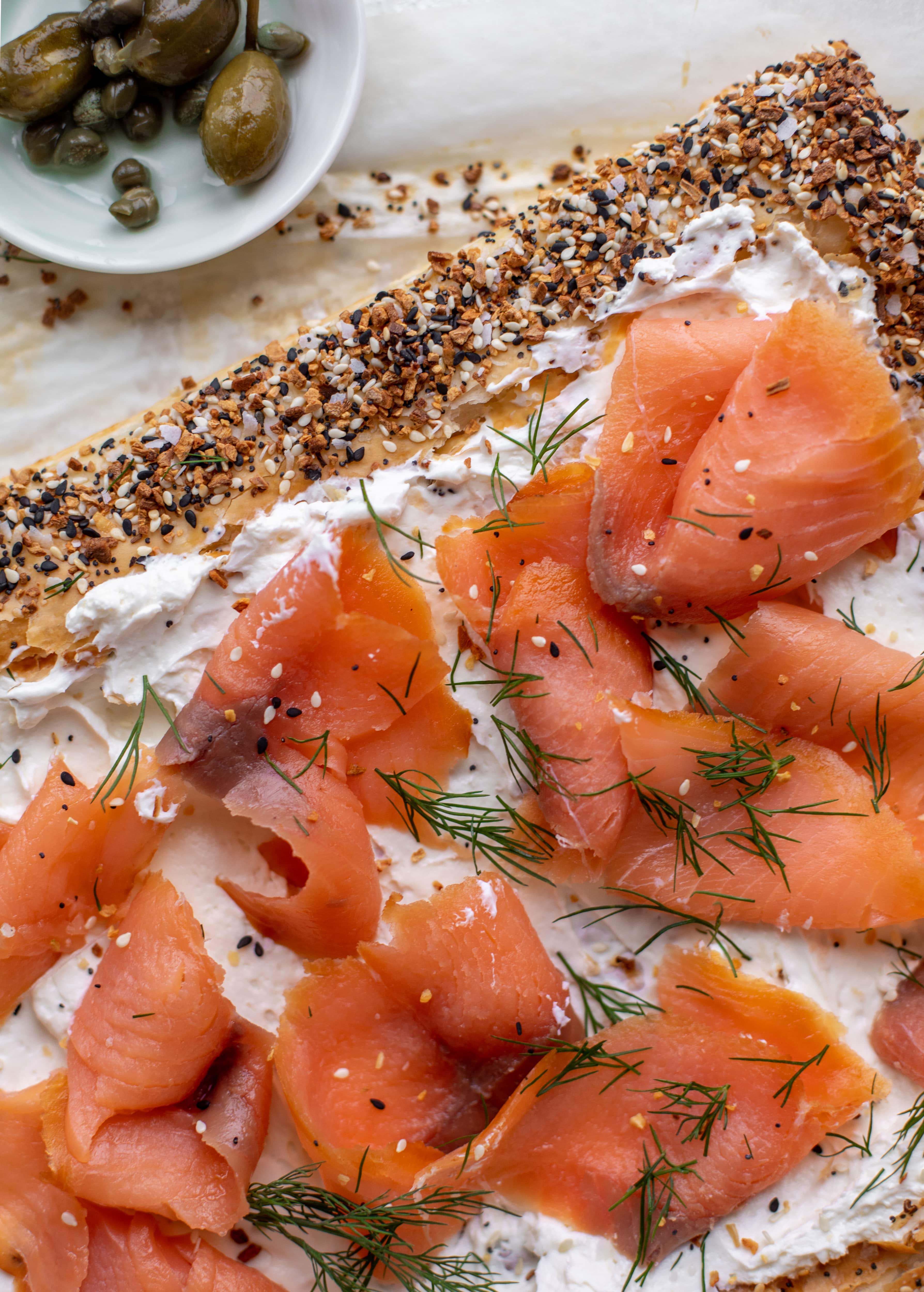 This everything smoked salmon tart is perfect for brunch! Puff pastry sprinkled with everything seasoning, slathered in cream cheese and topped with salmon.