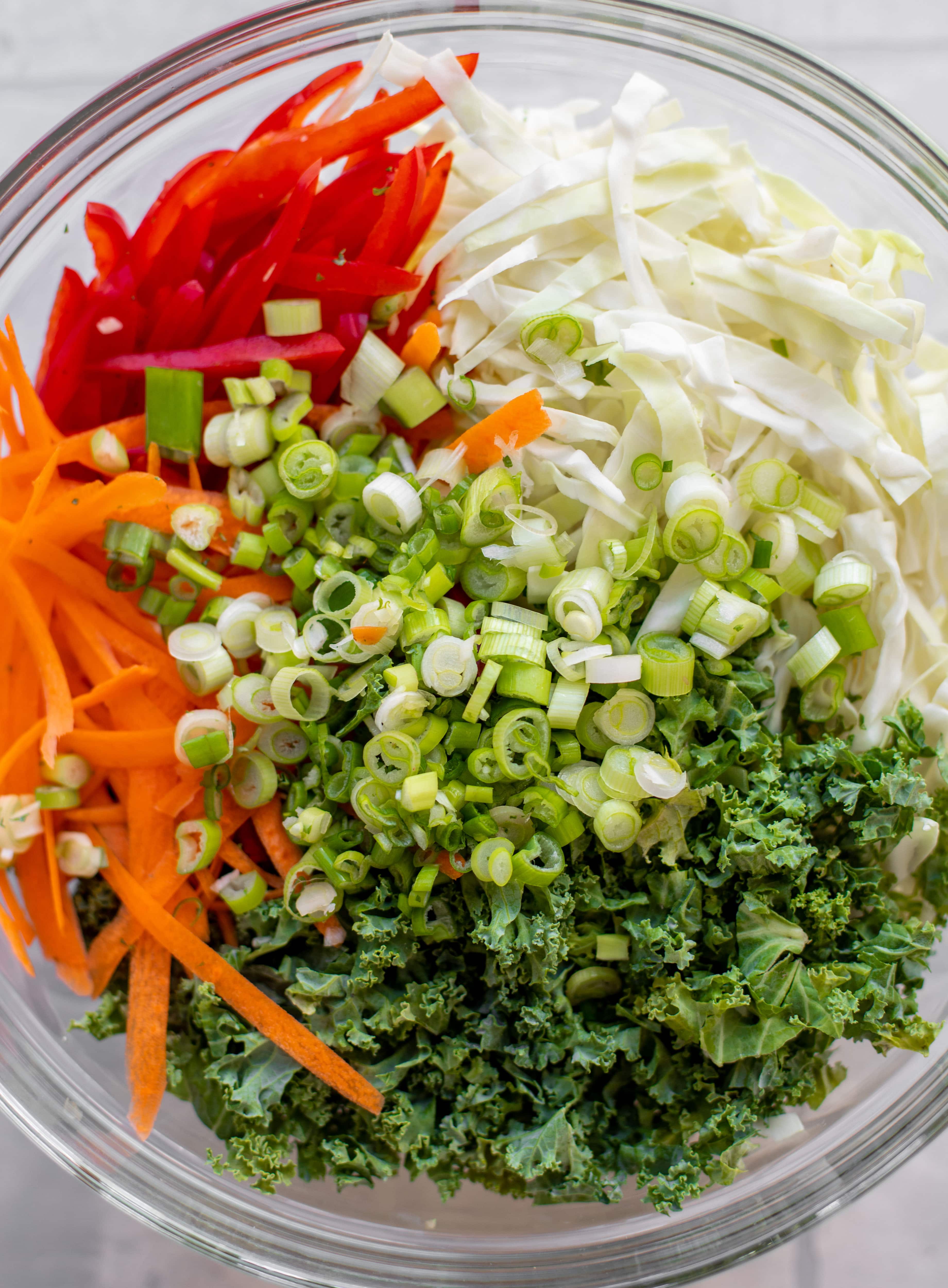 cabbage, kale, red pepper, carrot, scallions in a bowl. 