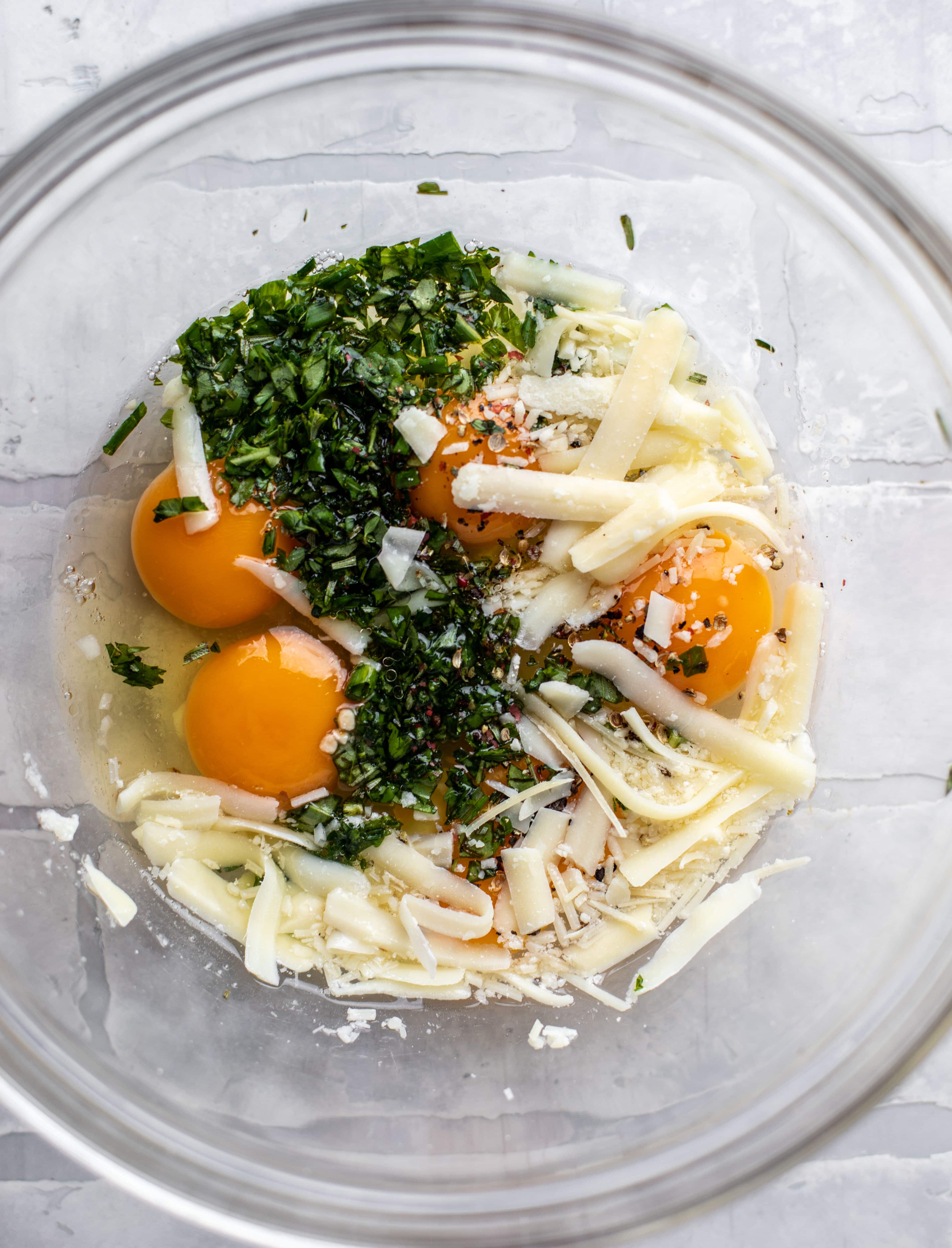 eggs, cheese and herbs in a bowl