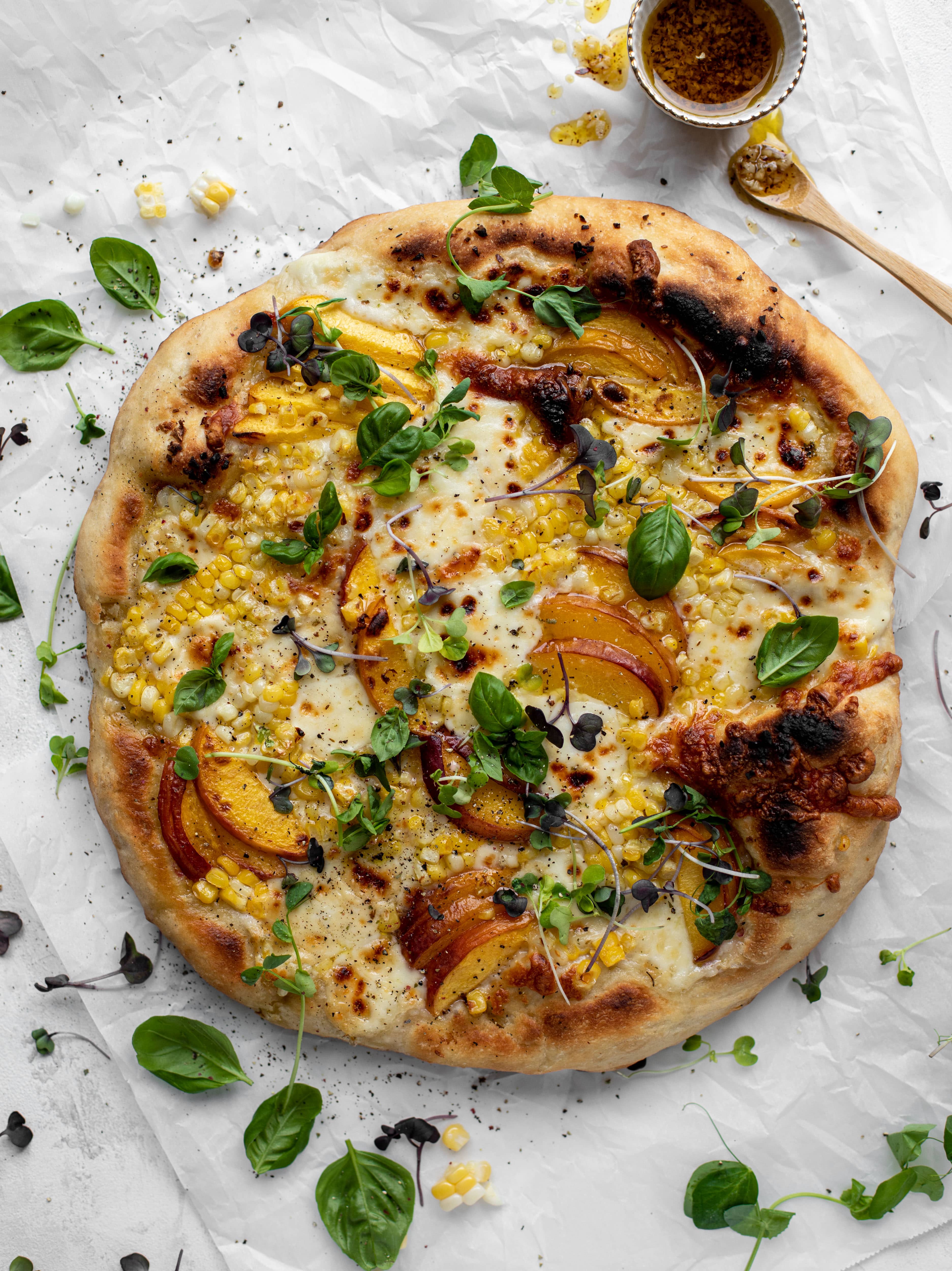 grilled peach pizza with corn and chili garlic oil