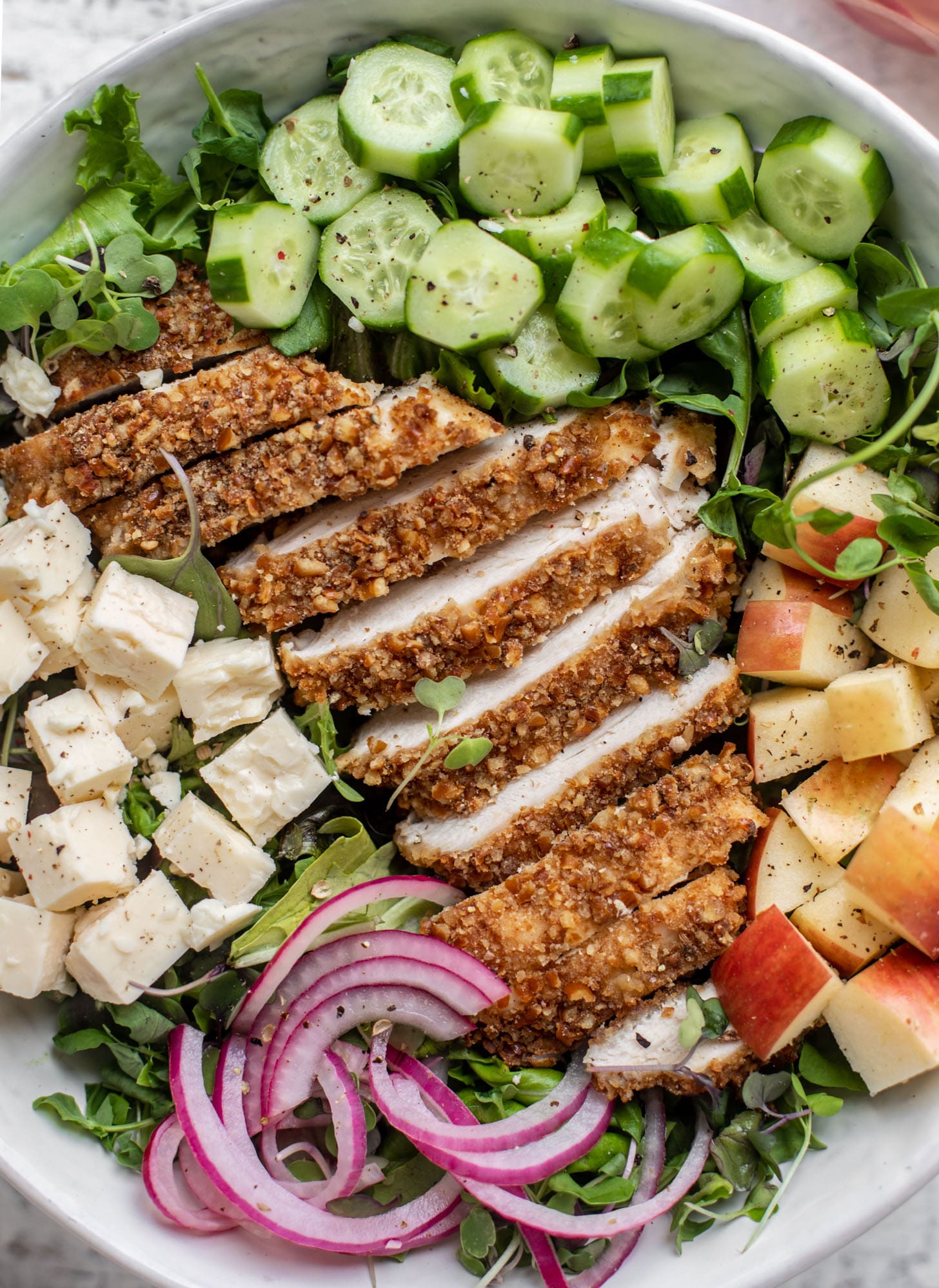 pretzel crusted chicken salad with onions, cheese, cucumbers and apples