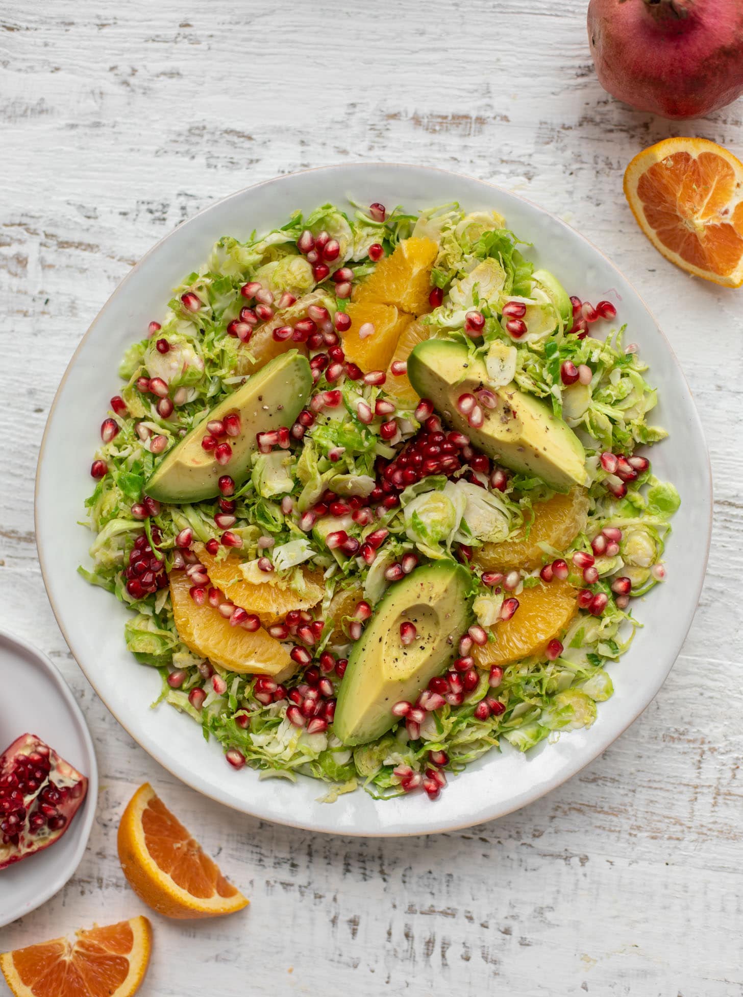 shredded citrus brussels sprouts salad with avocado and pomegranate